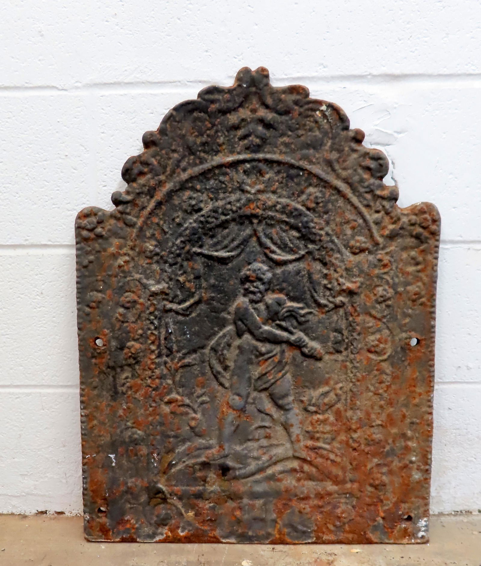 A cast iron fire back depicting a bearded man holding what appears to be a torch, 18th/19th century: A cast iron fire back depicting a bearded man holding what appears to be a torch, 18th/19th century - surface rust, but overall good condition. The figure possibly Greek mythology figure Prometheus, g