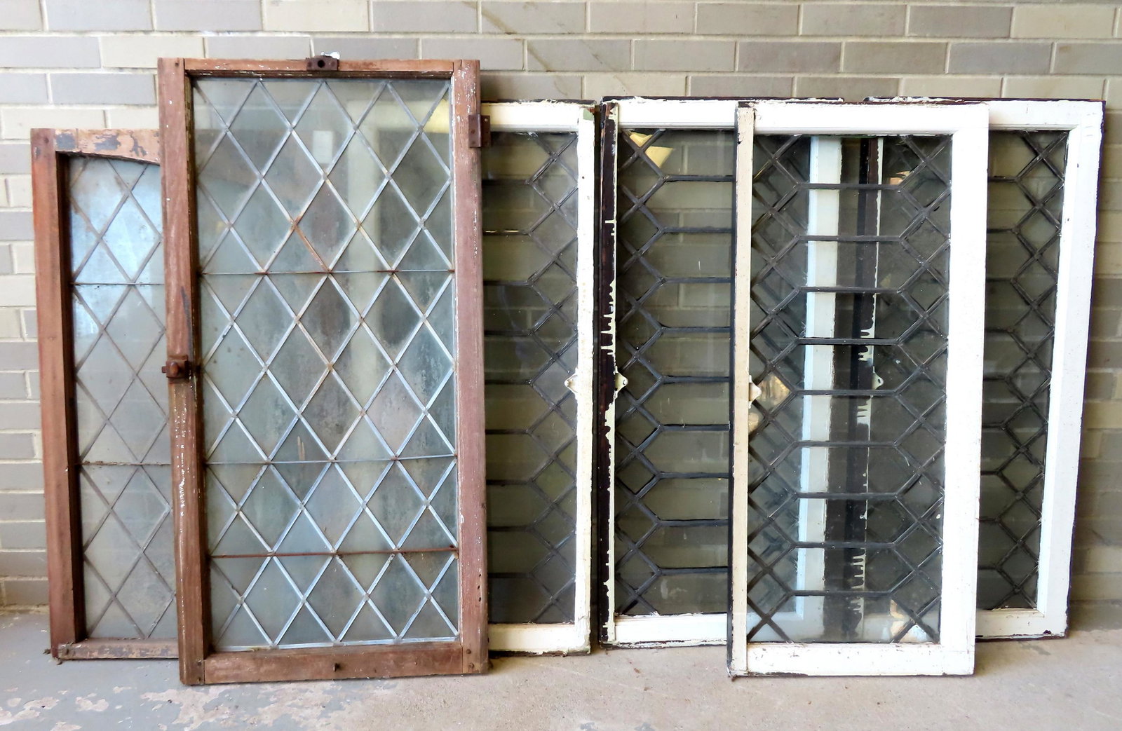 A grouping of 6 leaded glass windows including 4 matching. The 4 matching windows measure 19"W x: A grouping of 6 leaded glass windows including 4 matching. The 4 matching windows measure 19"W x 44"H x 1 3/4" thick. Two of the 4 matching windows with slight bows in the leaded glass but all 6 are i
