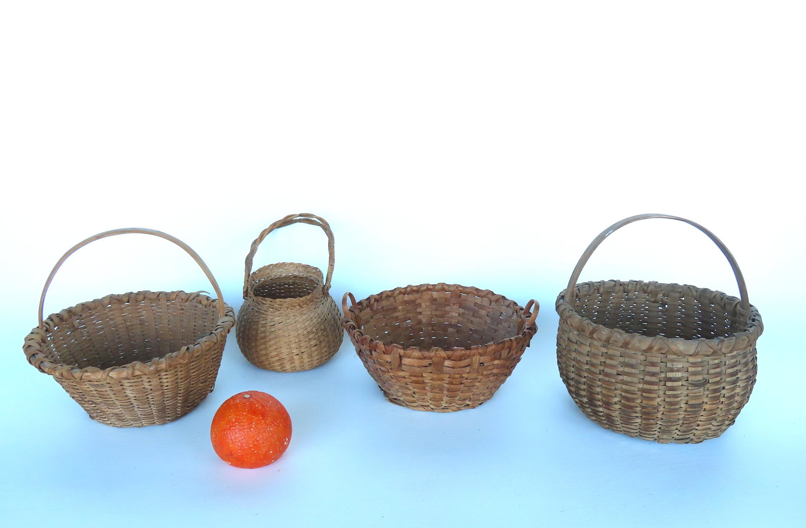 Grouping of 4 splint baskets including, most 19th century: Small Taghkanic basket with loop handle,: Grouping of 4 splint baskets including, most 19th century: Small Taghkanic basket with loop handle, double crossed rim, and pushed up bottom - 8"D x 8 1/2"H - one splint separation otherwise no damage