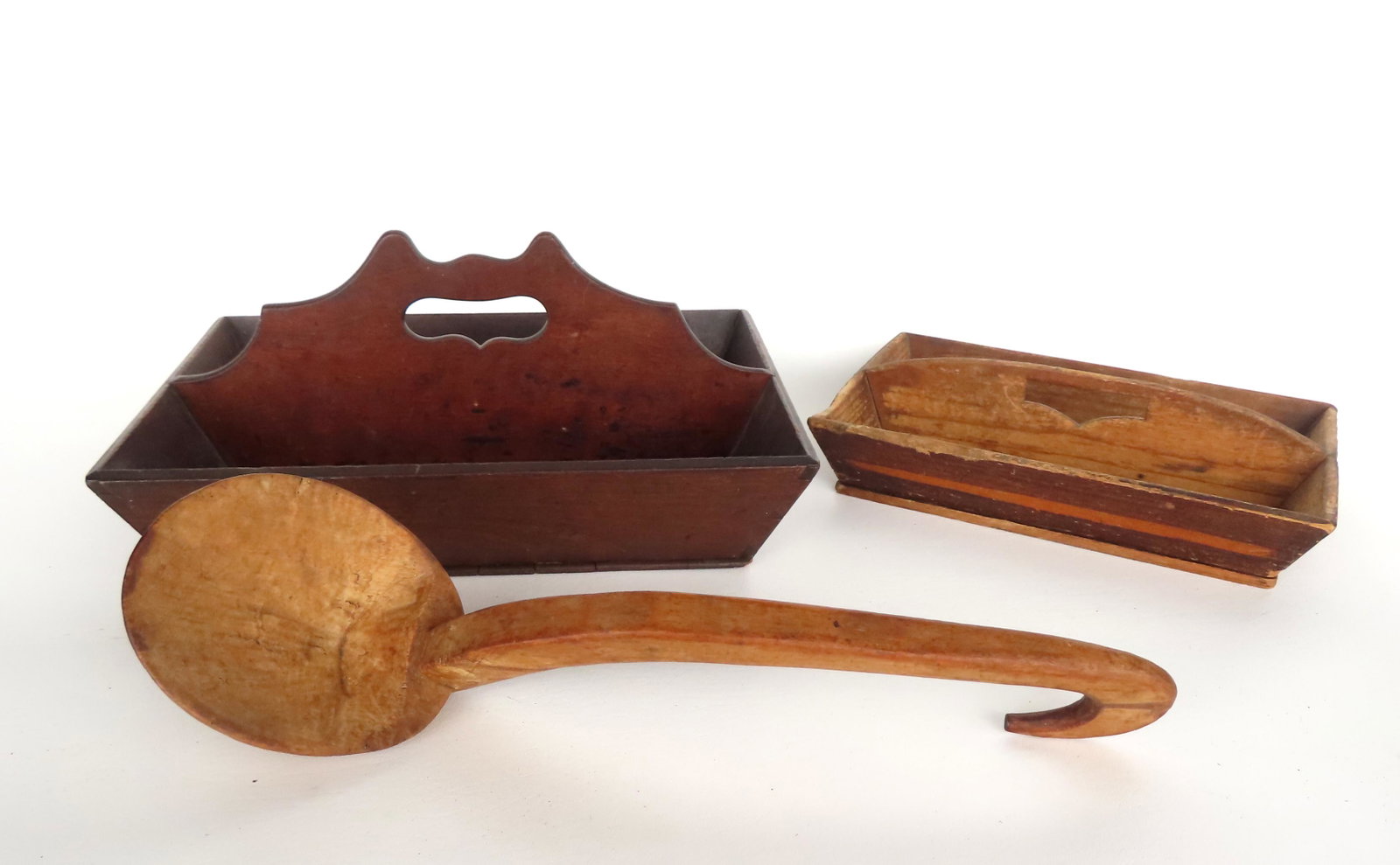 Three early kitchen treenware collectibles, 19th century, including: A refined walnut cutlery box: Three early kitchen treenware collectibles, 19th century, including: A refined walnut cutlery box with shaped handle in cat ears design and also having canted and dovetailed sides - 15"W x 11"D x 6 1/