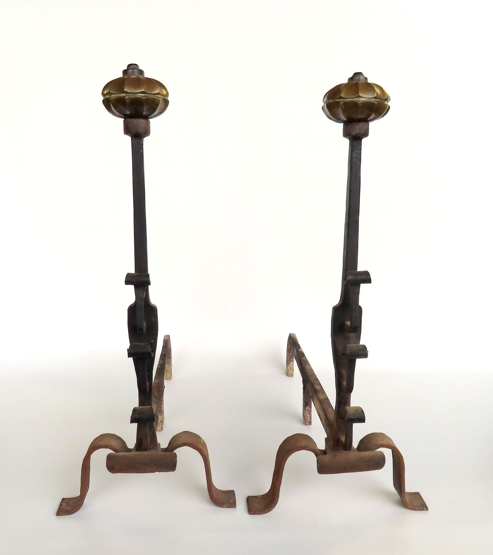 A pair of hand forged iron andirons with brass floral finials, late 18th to early 19th century, very: A pair of hand forged iron andirons with brass floral finials, late 18th to early 19th century, very good condition. Measures 23"D x 10"W x 23"H.