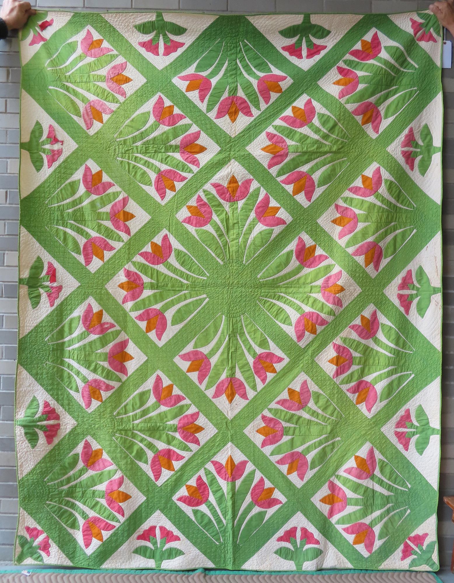 A graphic floral applique quilt, hand sewn, late 19th century. Small stains on side, some loose: A graphic floral applique quilt, hand sewn, late 19th century. Small stains on side, some loose threads that hold flowers/leaves in place that need repair (see photos), else good condition. 73" x 96".