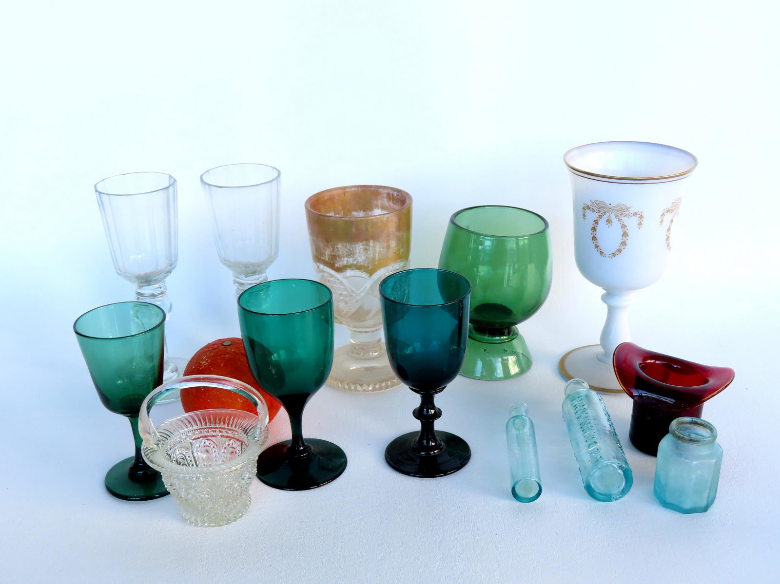 A grouping of early glassware and bottles including: Opaque white goblet decorated with gilded: A grouping of early glassware and bottles including: Opaque white goblet decorated with gilded wreaths 7 "H x 3 3/4" diameter; a light green goblet with scared pontil; 2 multi-faceted wine glasses att