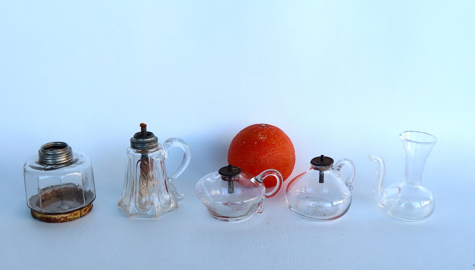 Grouping of miniature lighting devices and related, early to mid 19th century, including: Two spark: Grouping of miniature lighting devices and related, early to mid 19th century, including: Two spark lamps - one with loss to the curl at terminal of finger - both with scarred pontils and otherwise go