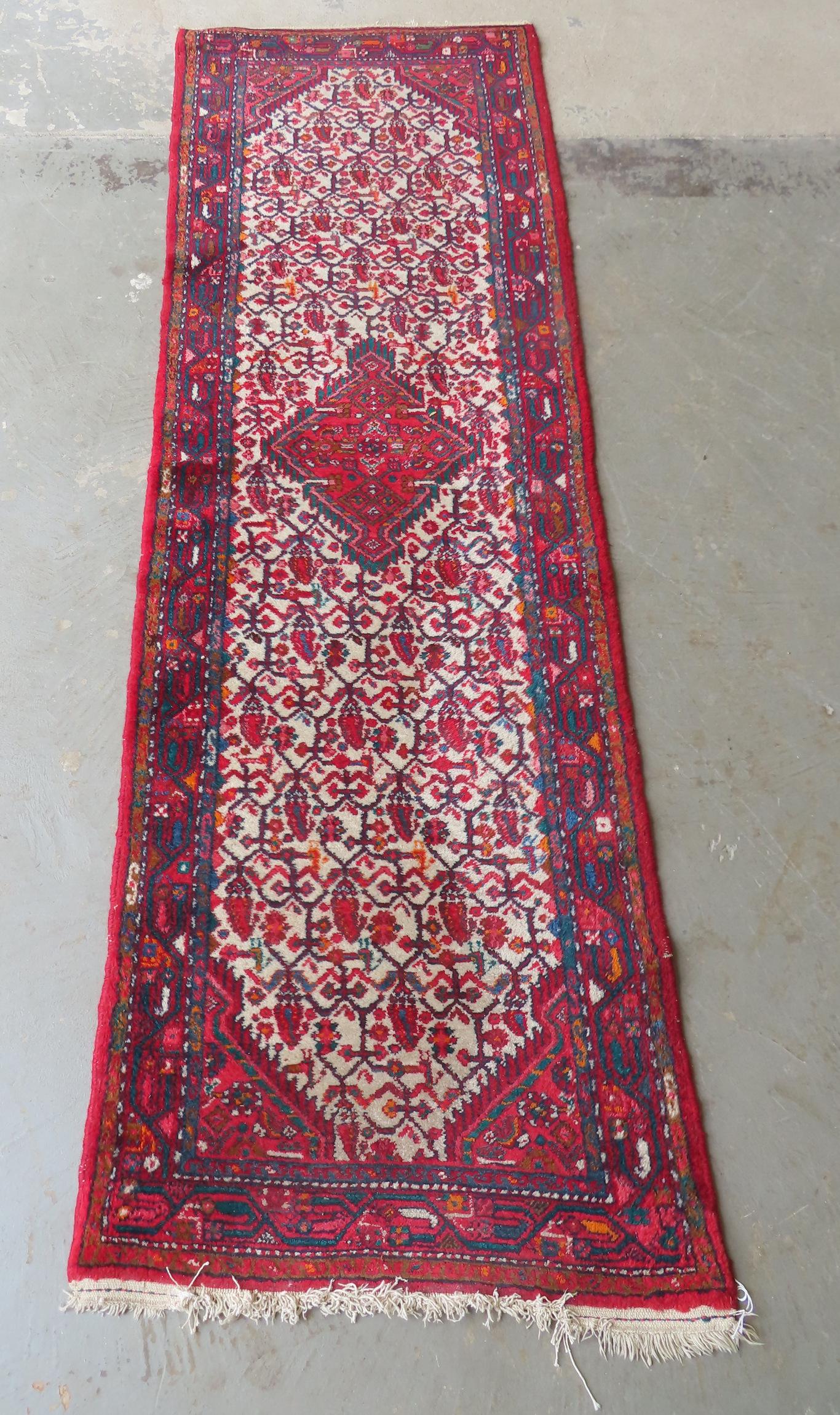 An oriental runner, thick wool pile, Iran label on reverse, very good condition. Mid 20th century.: An oriental runner, thick wool pile, Iran label on reverse, very good condition. Mid 20th century. Measures 2' 6" x 8' 7".