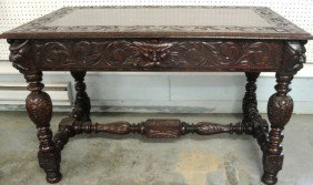 Ornate Victorian black walnut partner's desk with: Ornate Victorian black walnut partner's desk with hand-carved apron, legs and cross-stretchers (NOTE: Lion's head carvings on drawer pulls, Northwind faces on tops of all four legs). 30"W x 48"L x 28.