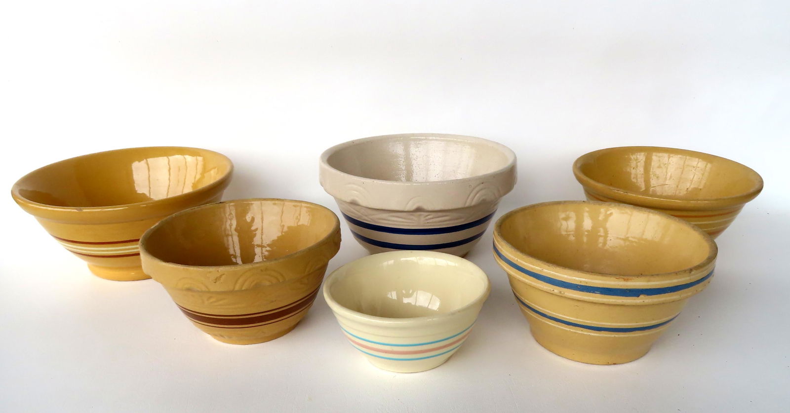 A grouping of yellowware and stoneware mixing bowls ranging in size from 5 1/4"H to 10 1/4" (1 of 8)