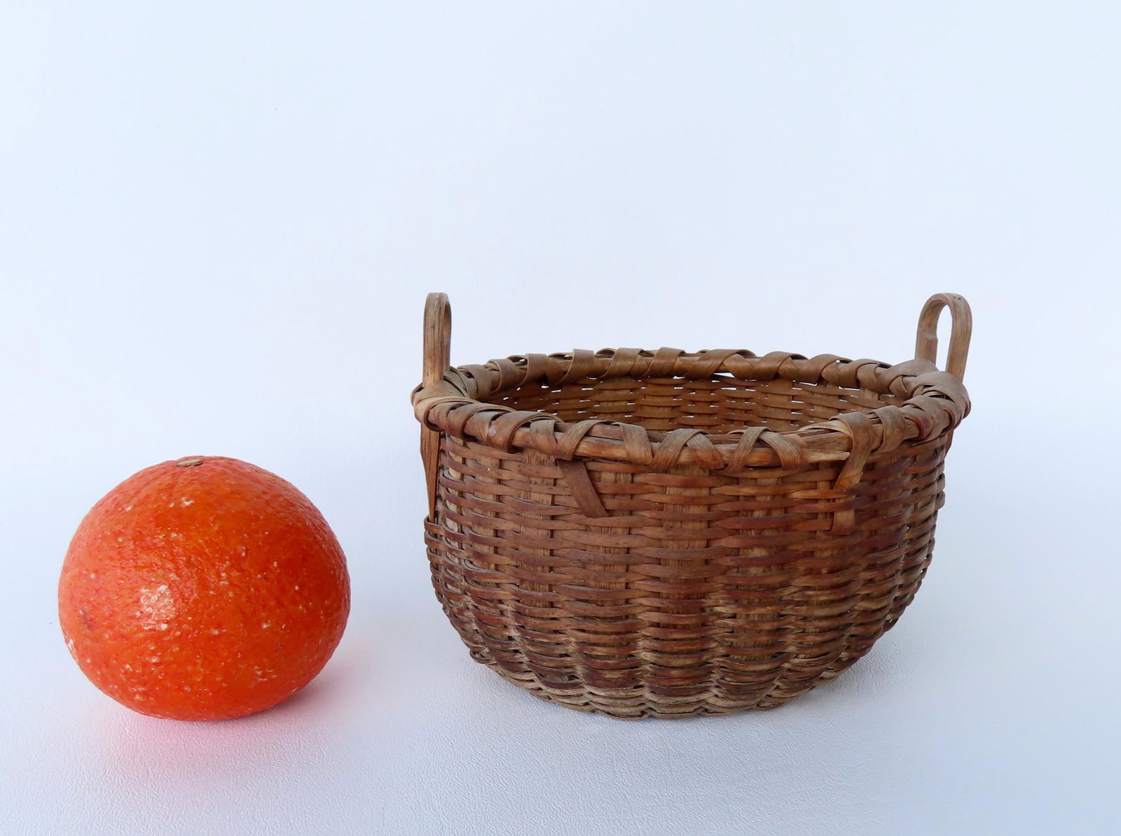 A small Taghkanic basket with 2 loop handles, and typical pushed up bottom and crisscrossed rim, (1 of 7)