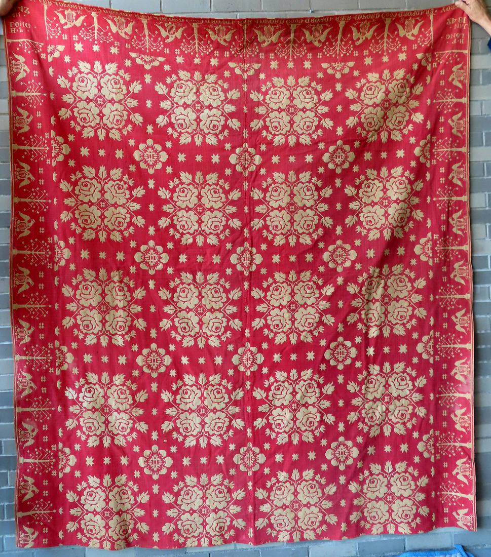 A red and white Jacquard floral coverlet with hand sewn center seam. The border decorated with (1 of 8)