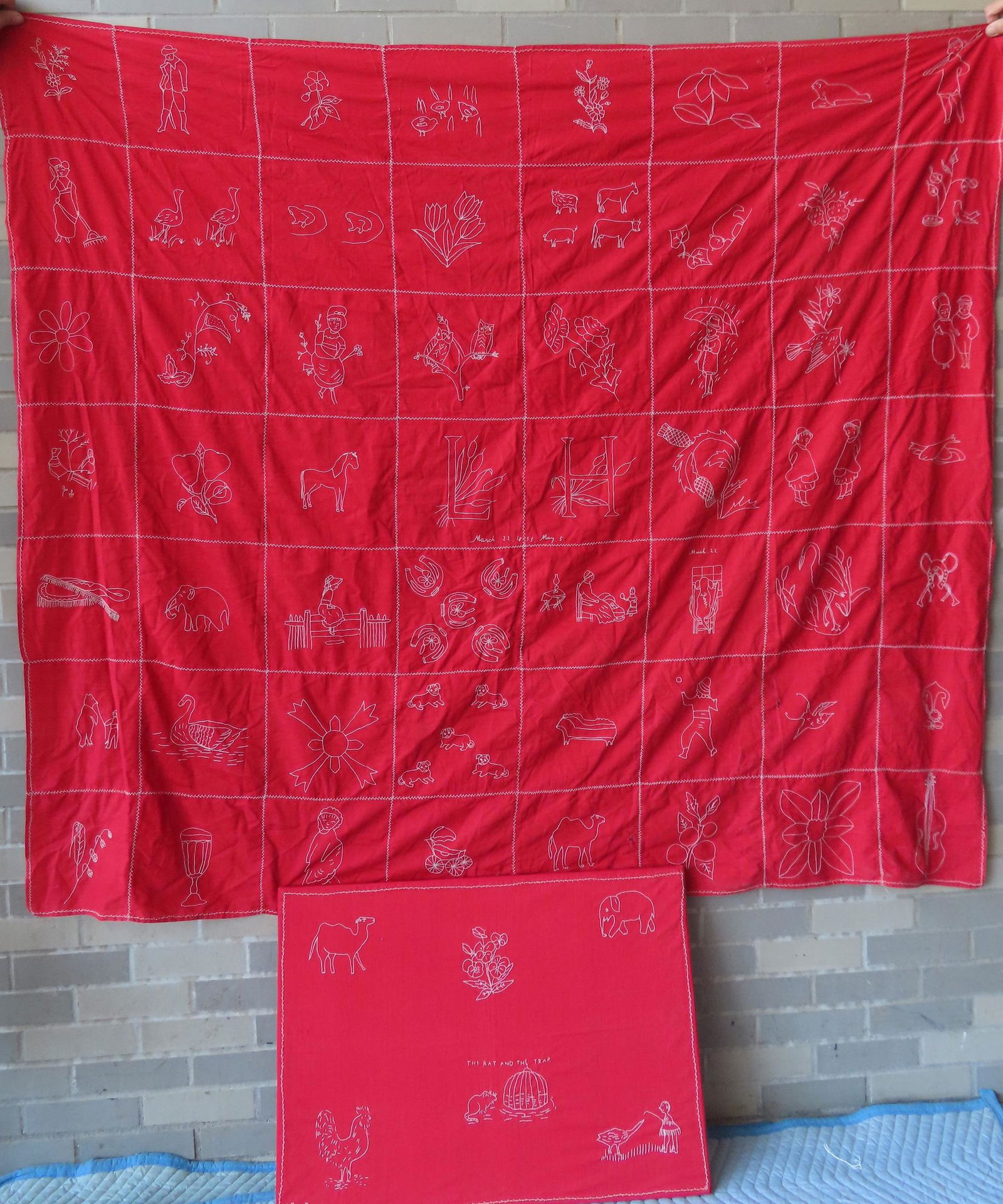 Two child's embroidered quilts with white stitches on red cotton fabric. The first a youth size (1 of 9)
