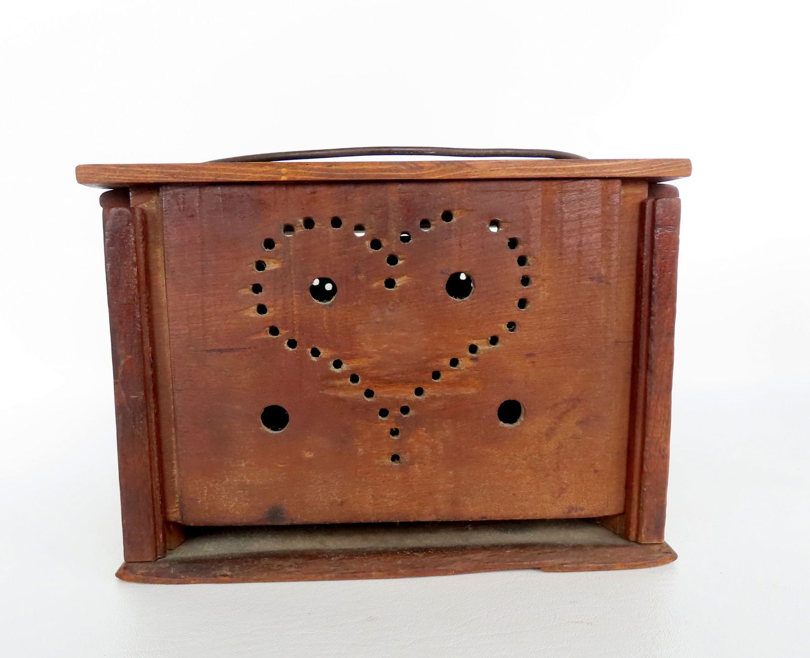 A wooden foot warmer with a pierced heart design on the pull-up door, the sides with pierced circles: A wooden foot warmer with a pierced heart design on the pull-up door, the sides with pierced circles and the back with the initials J.G. - it has a hand forged iron removable tray on the interior and