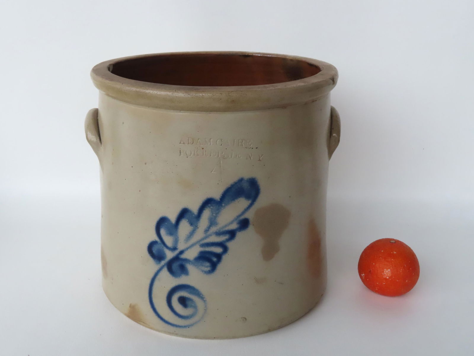 Stoneware 4 gallon crock decorated with a cobalt blue leaf, with the impressed mark of "Adam Caire / (1 of 7)