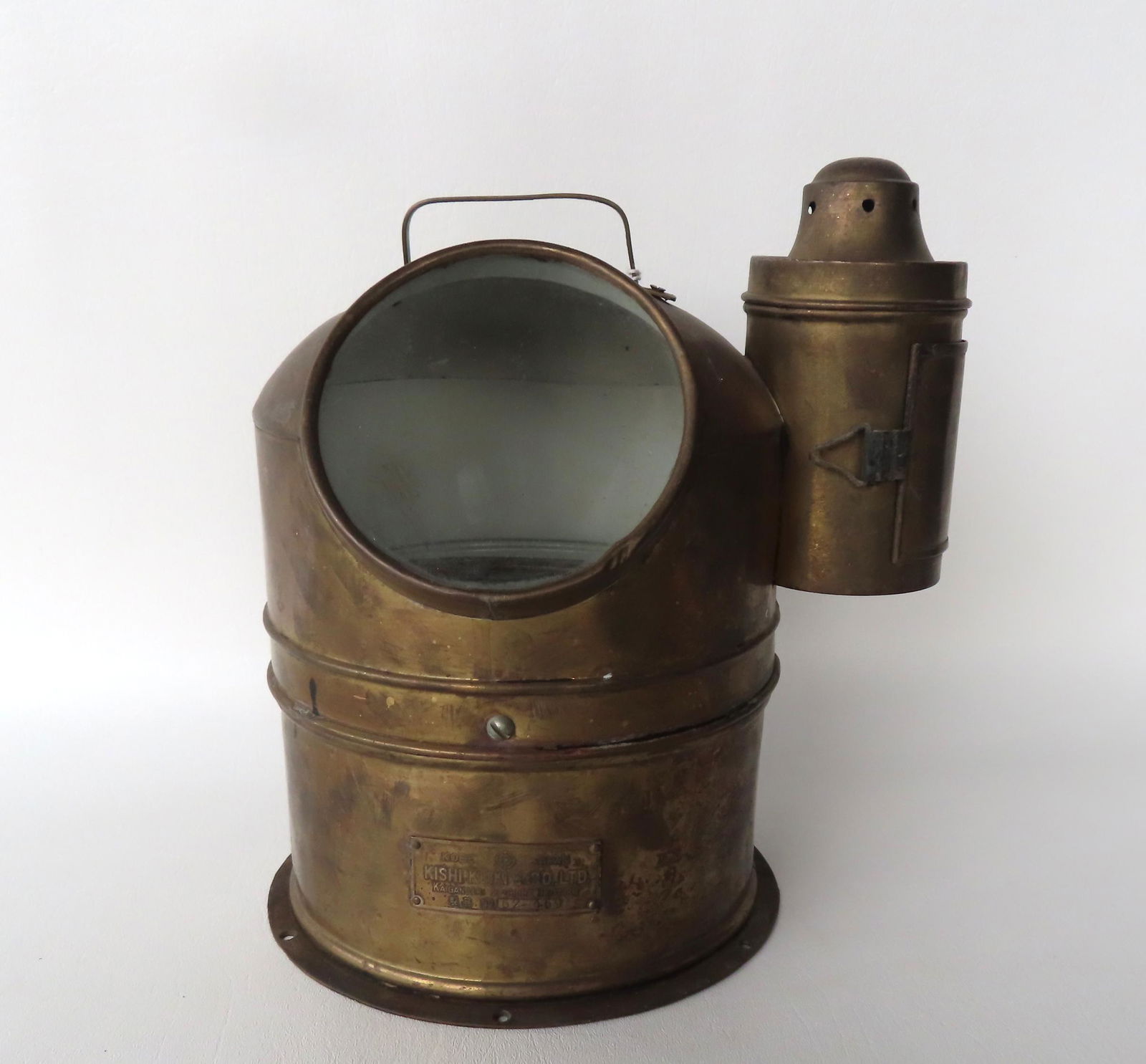 A nautical compass housed within a brass cylinder with glass face, with attached lighting device (1 of 6)