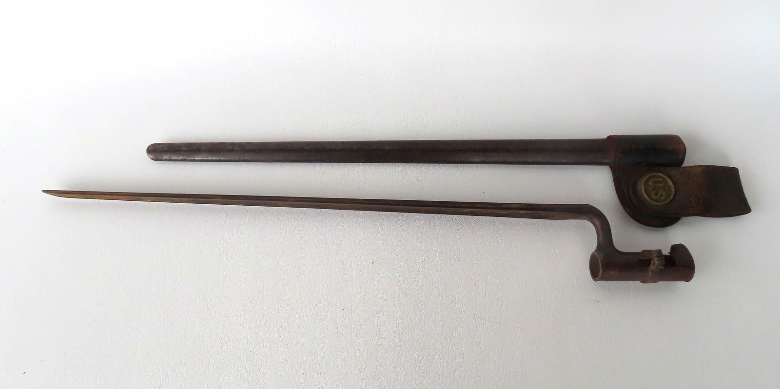 A Civil War era bayonet with leather scabbard. Scabbard with attached "U.S." brass medallion, and (1 of 5)