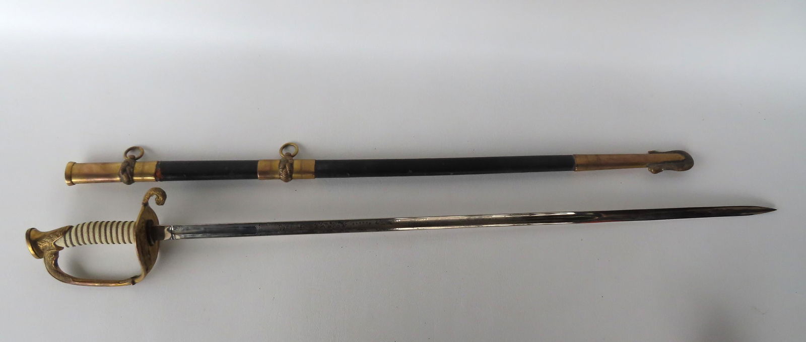 A US naval officer's sword marked "Made U.S.A.", with original scabbard. Engraved blade marked (1 of 13)