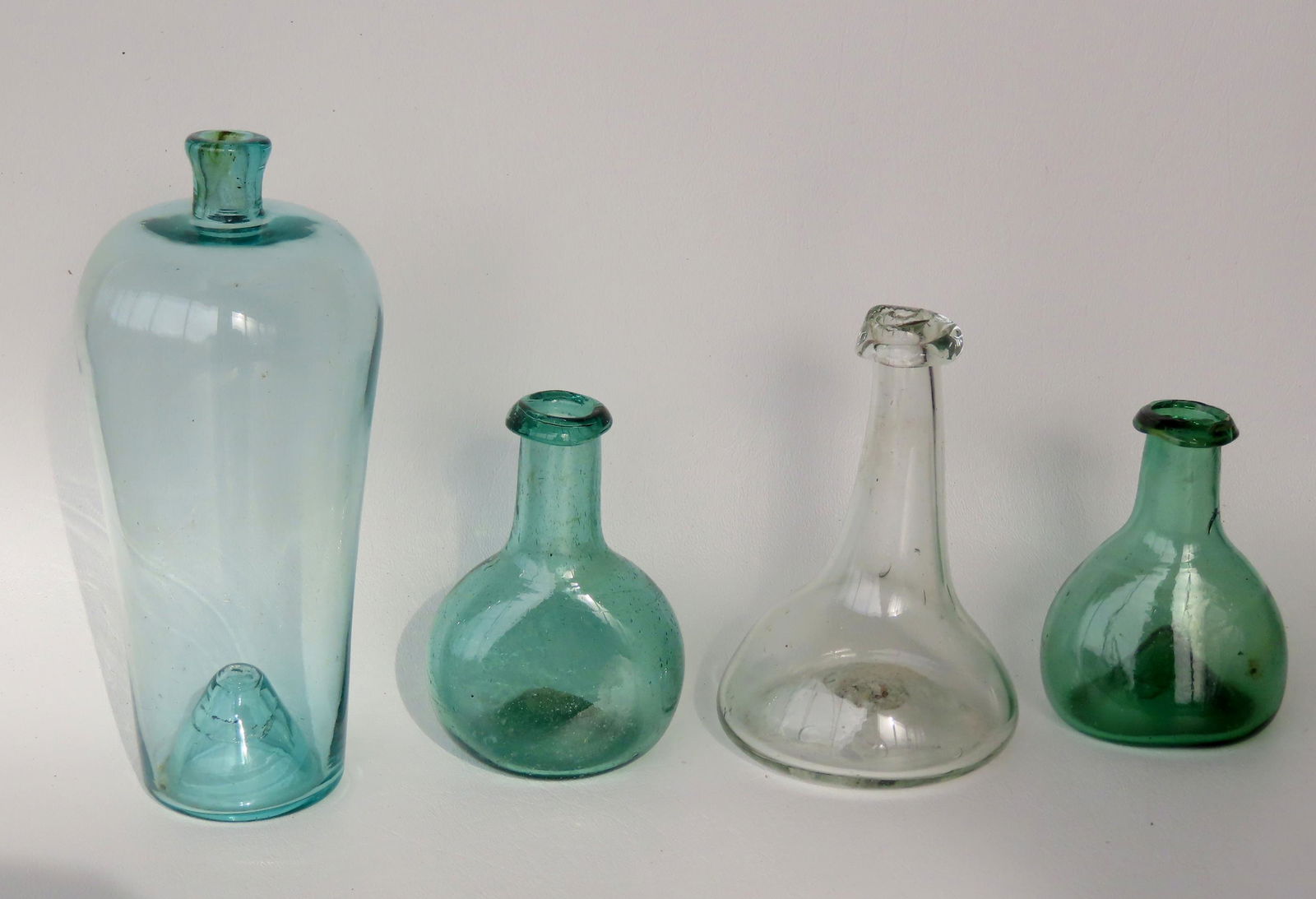 Grouping of 4 small bottles including: Colorless with long neck, crudely applied lip, slightly (1 of 19)
