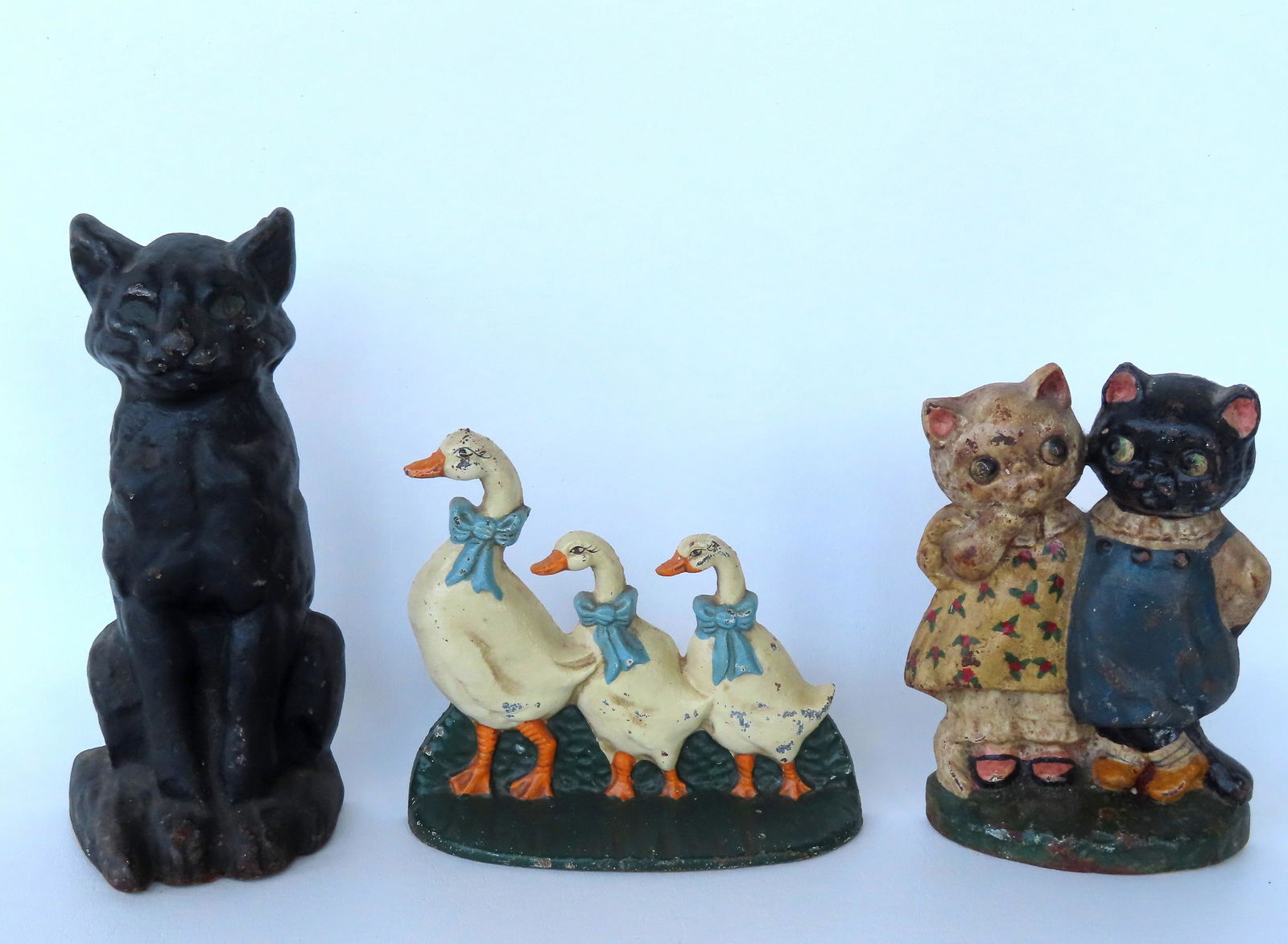 Three cast iron door stops including 2 standing kittens, 3 ducks wearing blue ribbons, and the (1 of 7)