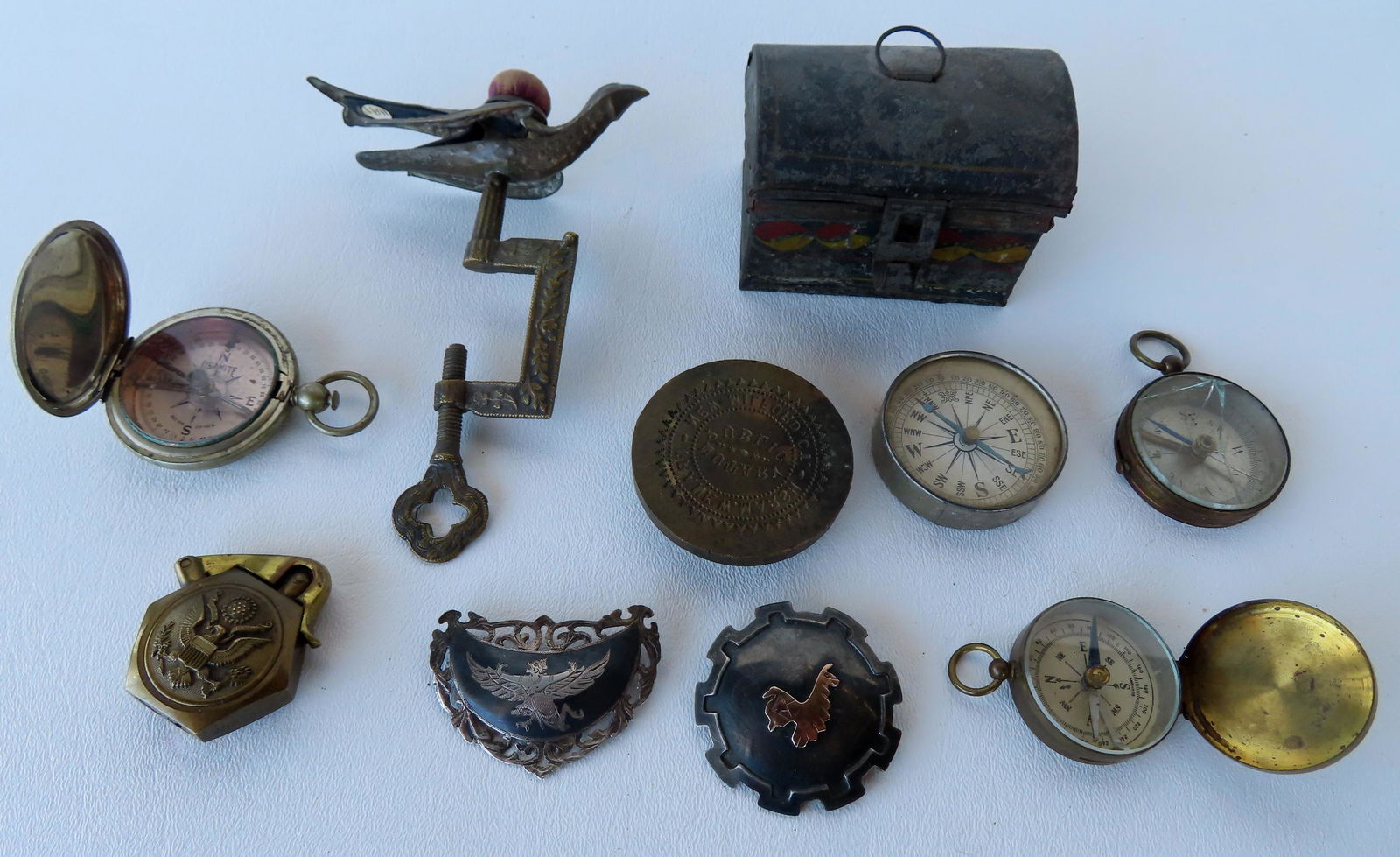 Grouping of decorative and military objects including: Silver brooch with applied gold llama central (1 of 9)