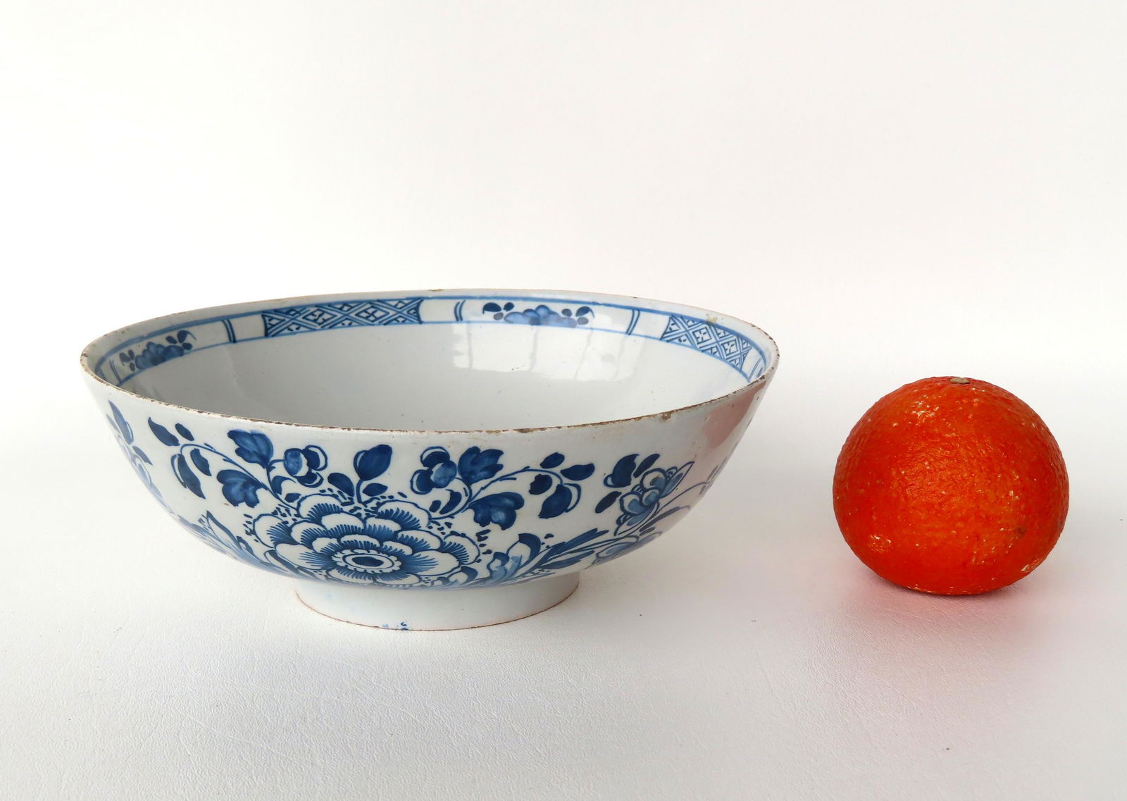 A Delft Liverpool punch bowl on footed base, decorated with a large blue flower across the front, (1 of 5)