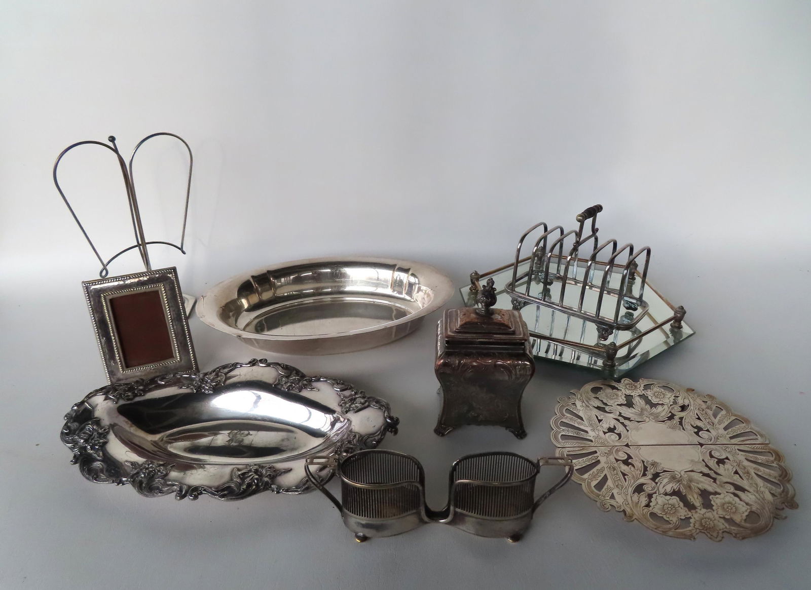 A grouping of silver plate including serving dishes, ornate engraved lidded tea caddy, condiment (1 of 4)
