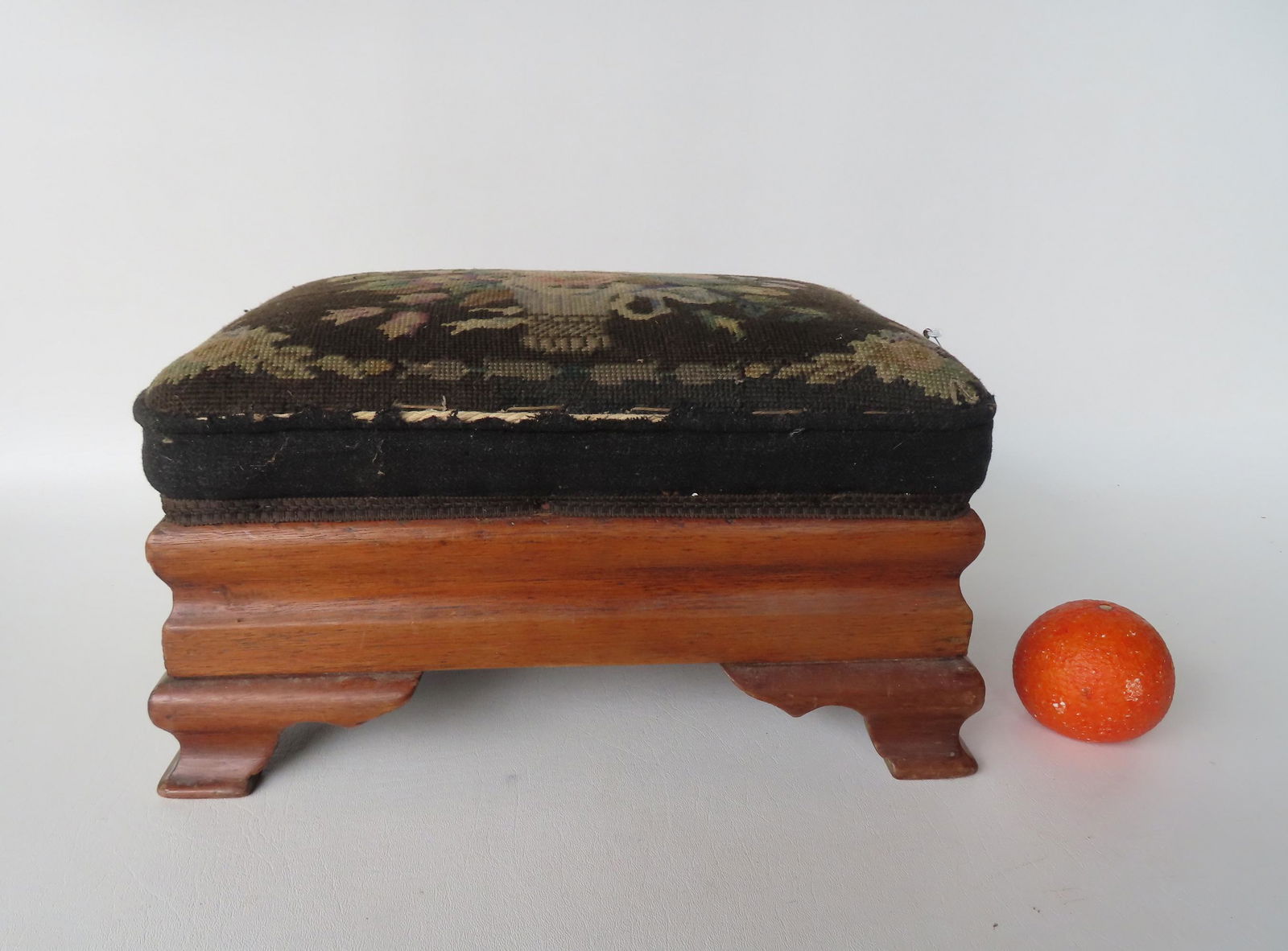 An Empire period mahogany foot stool with shaped and cutout base having a needlepoint top decorated (1 of 3)