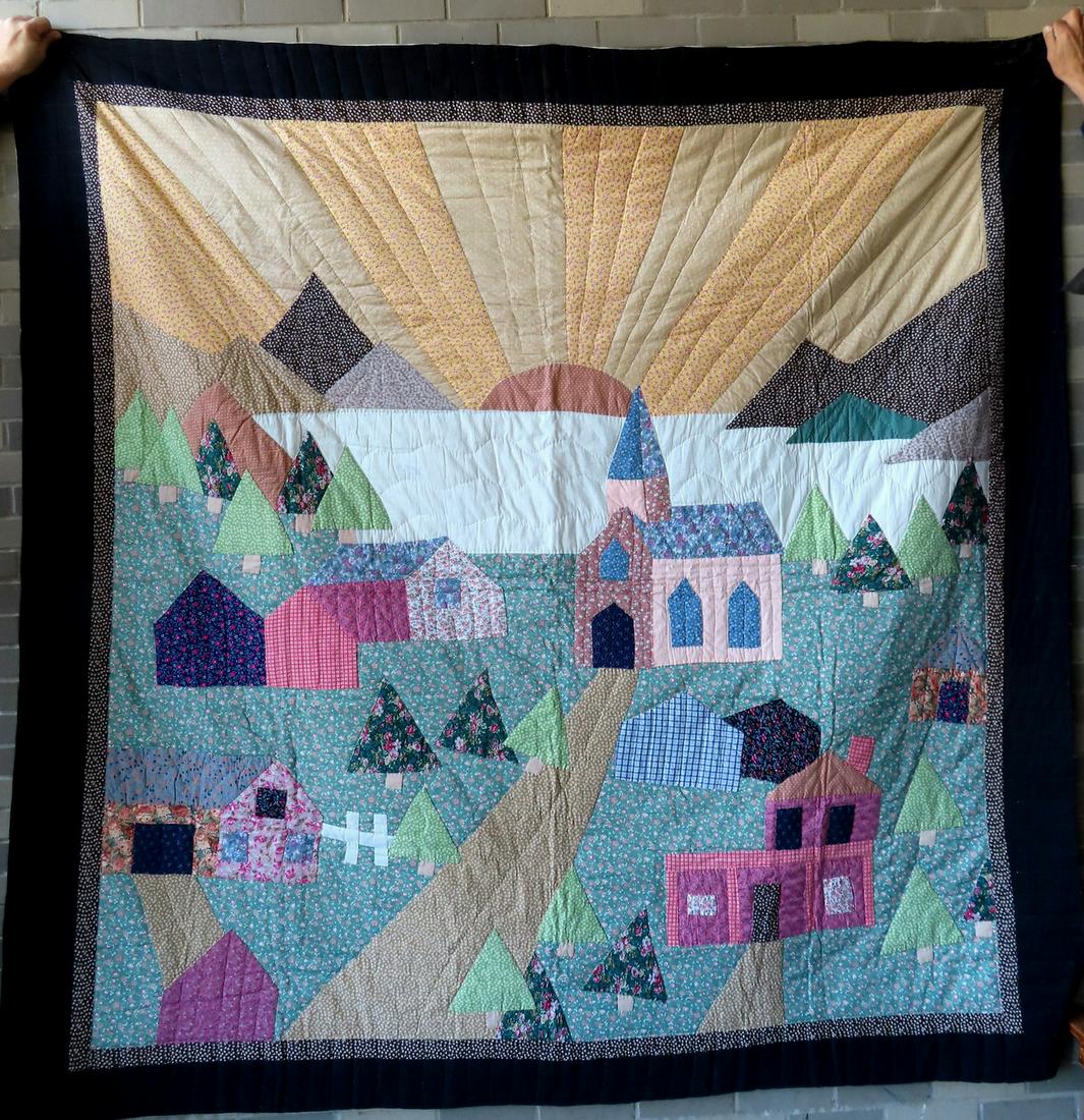 A modern Amish pictorial quilt, hand sewn, depicting the sun over the mountains, trees, building and (1 of 5)