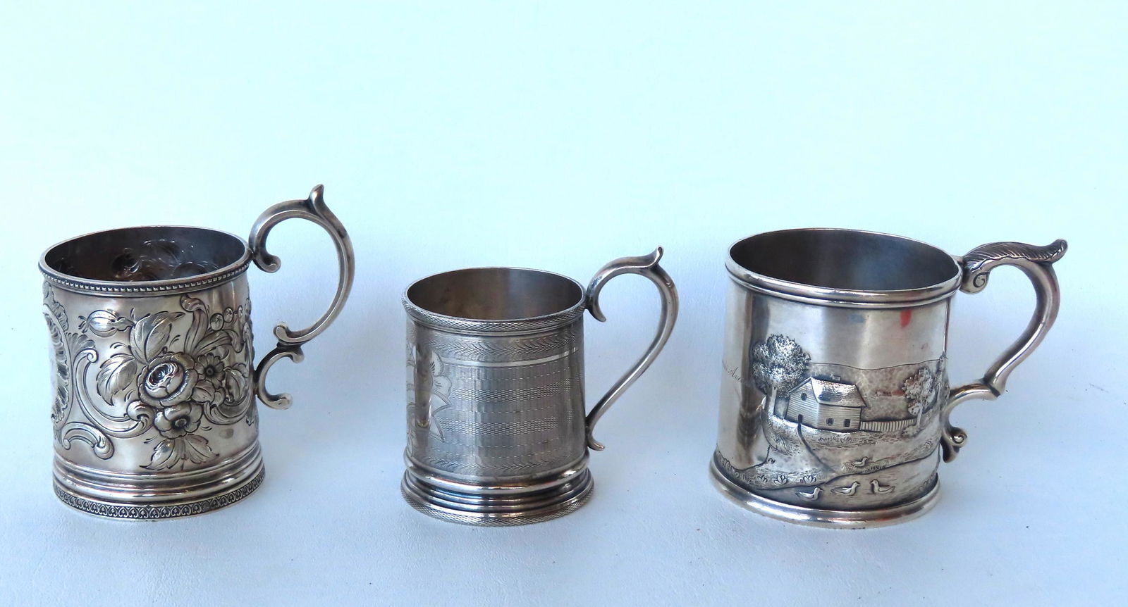Three  early silver cups of related family members. The first  repousse silver decorated with a (1 of 16)