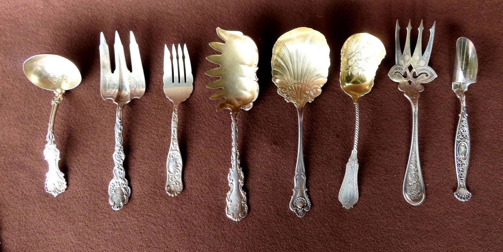Grouping of 8 ornate sterling silver serving spoons and forks including: Signed Quintard with gold (1 of 15)