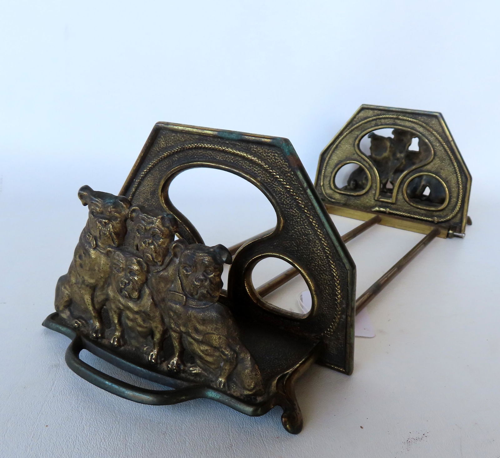 An Art Nouveau period adjustable bookends in the form of Bulldogs.: An Art Nouveau period gilded cast iron sliding bookends with bulldog terminals, early 20th century - one screw is missing and has been replaced with screw that doesn't fit (see photo) otherwise very g