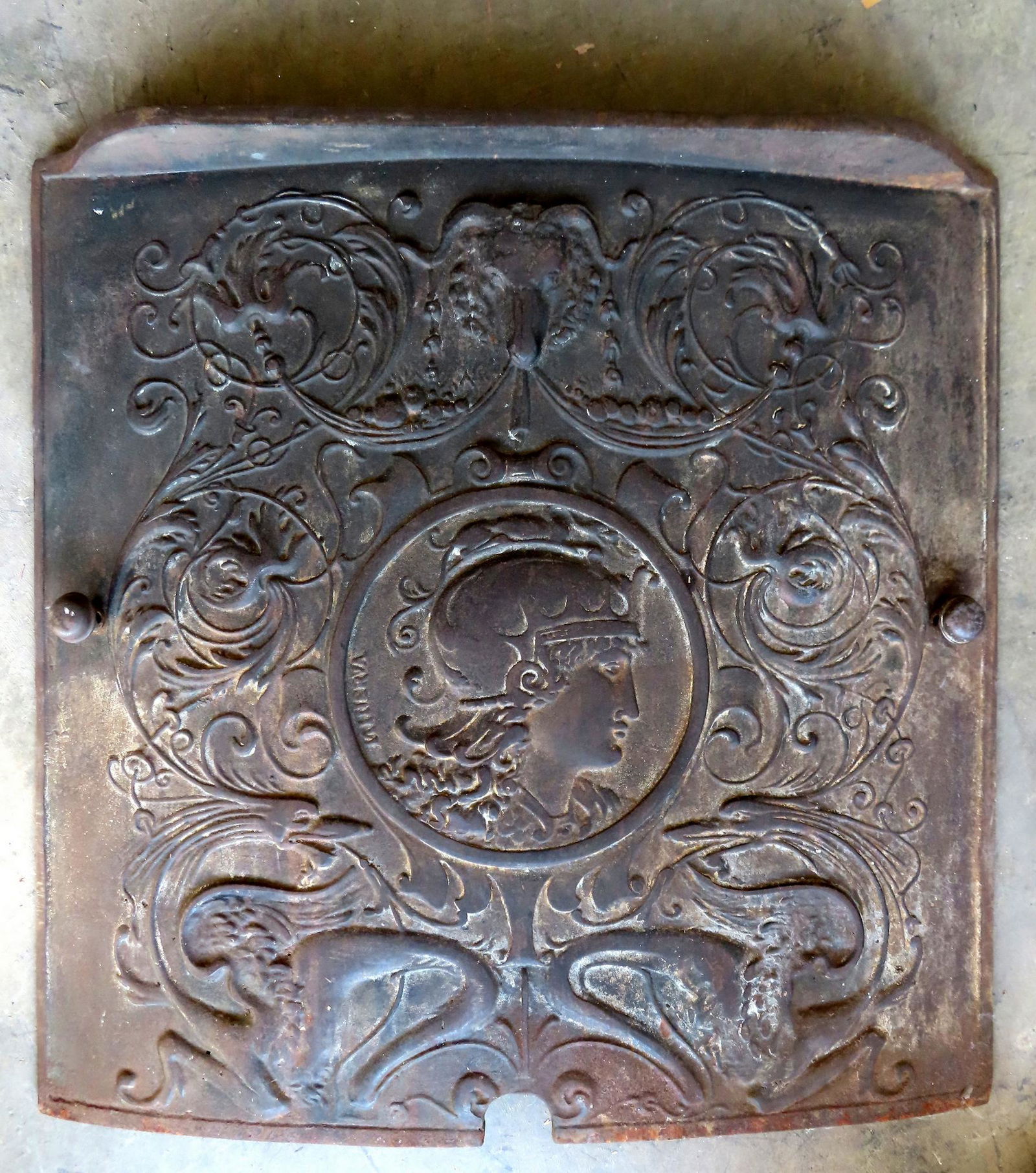 A cast iron stove plate, late 19th century decorated with Greek god Minerva.: A cast iron stove plate, late 19th century, decorated with the figure of the Greek goddess Minerva - she is the Roman goddess of wisdom, justice, law, victory, and the sponsor of arts, trade, and stra