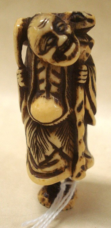 Bone or ivory Netske of smiling man with frog: Bone or ivory Netsuke of smiling man with frog on back.