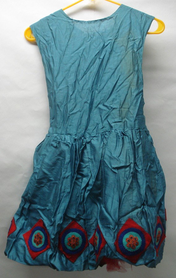 Two hand-sewn theatrical dresses.: Two hand sewn theatrical costumes: One an ornate sleeveless dress with black & white tassels around collar, green & red vertical stripes on bodice, black sequins around top of lower skirt with tassels
