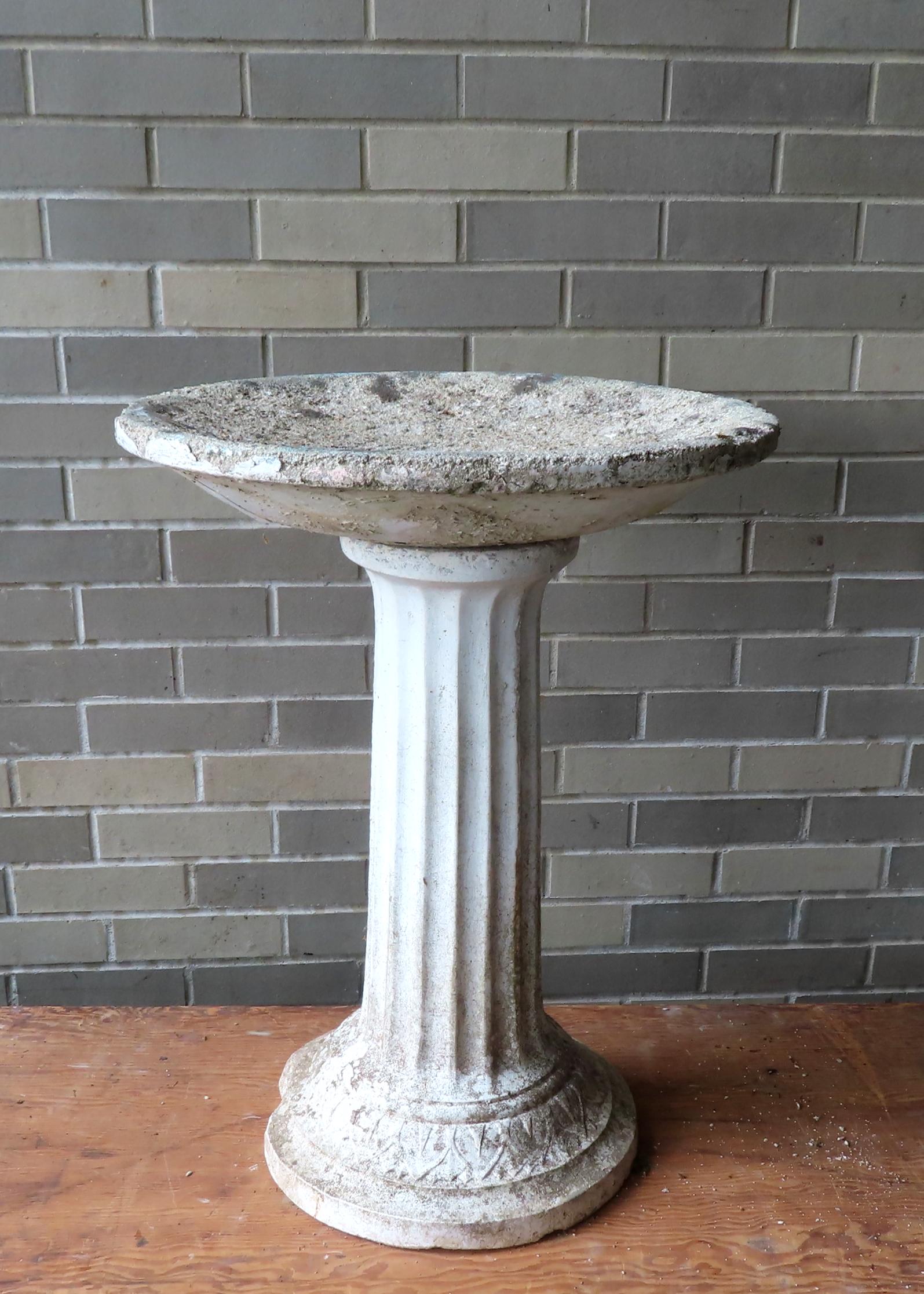 An Old Concrete Bird Bath. The Separate Rounded Top Is Mounted Atop A