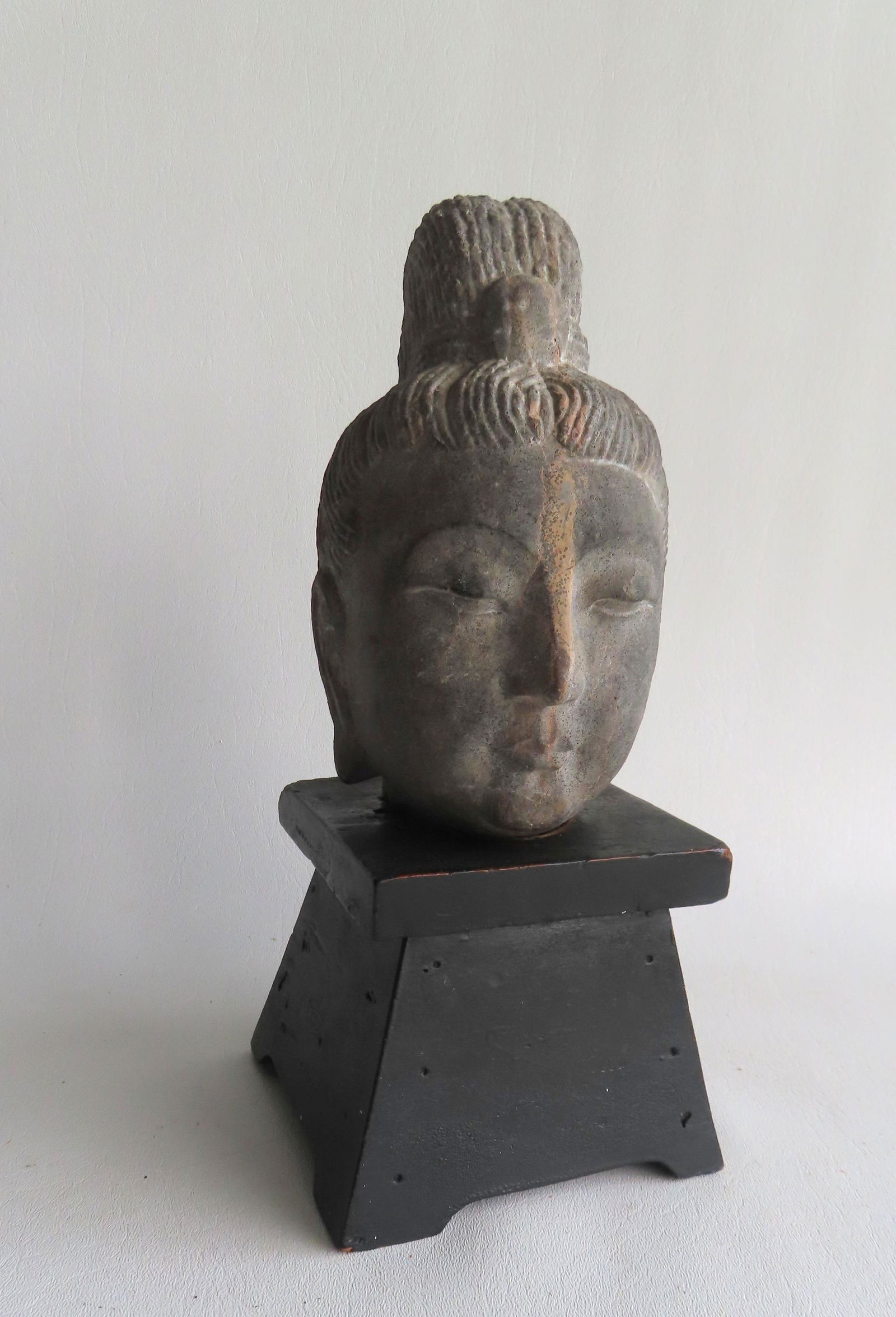 A carved stone figure head of a Hindu deity, probably 19th century, mounted on a newer painted black (1 of 6)