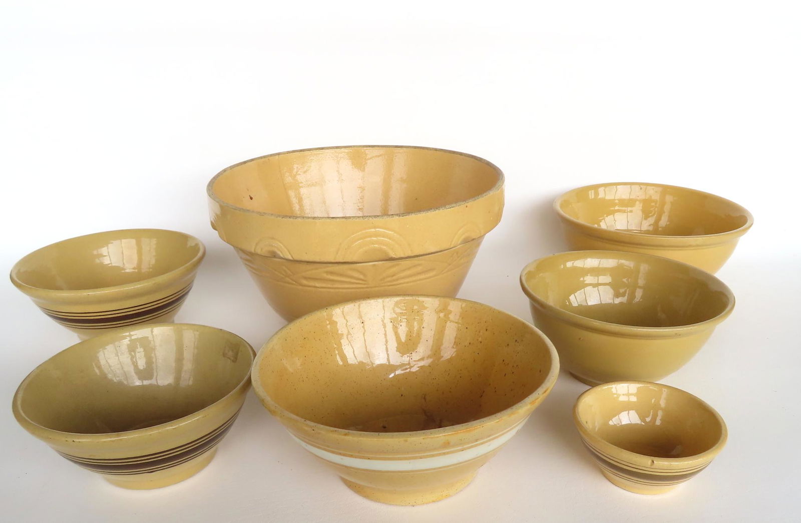 Grouping of 7 yellowware mixing bowls, most late 19th century. The largest early 20th century with (1 of 12)