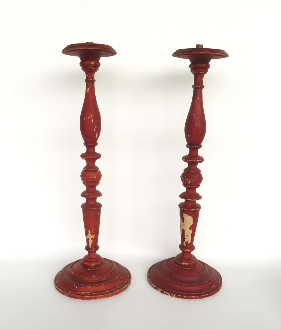 A pair of turned wooden candlesticks attached to a stepped circular base in worn red paint over (1 of 5)