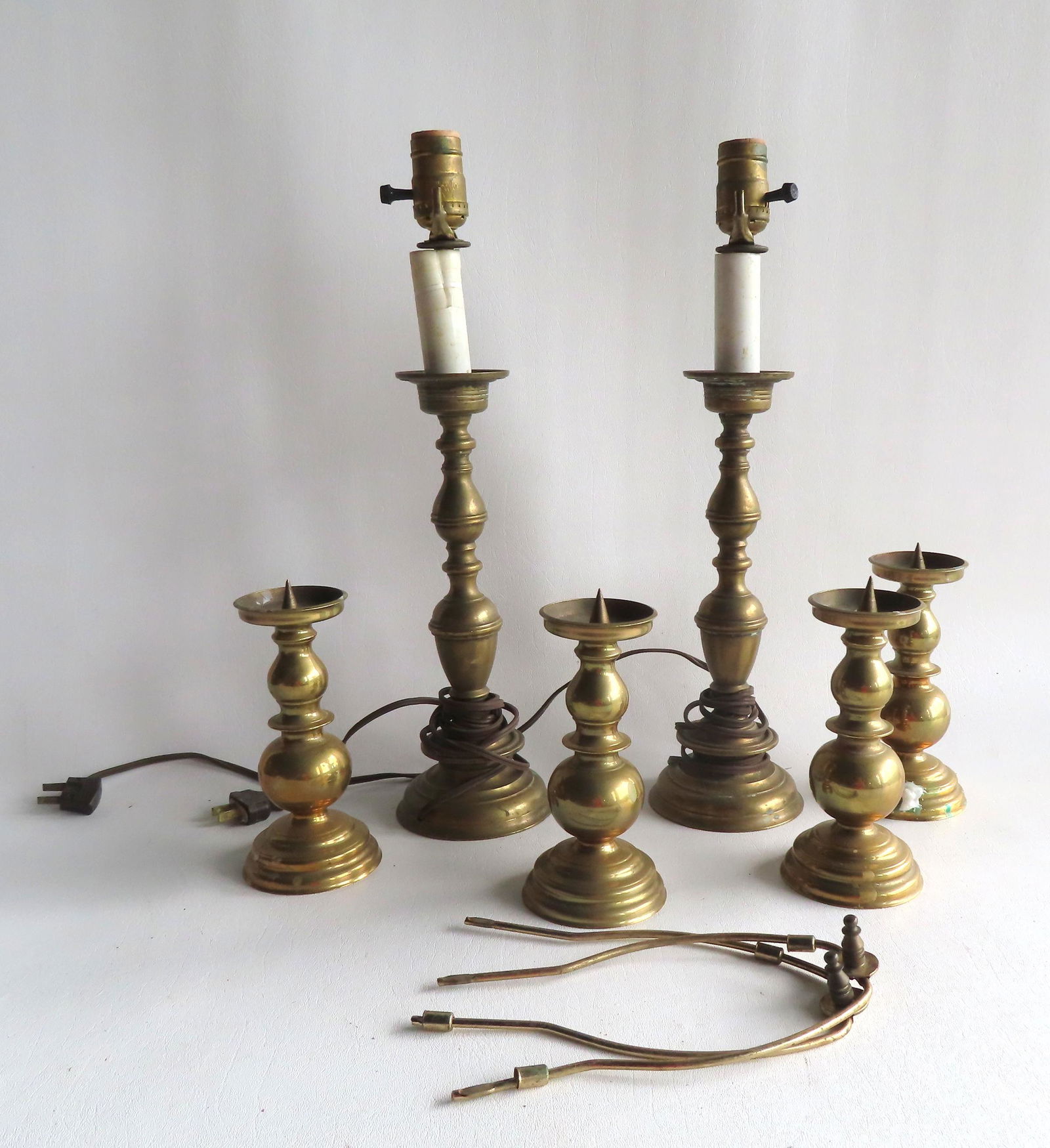 A grouping of brass pricket sticks and electrified candlesticks. The 4 matching pricket sticks (1 of 8)