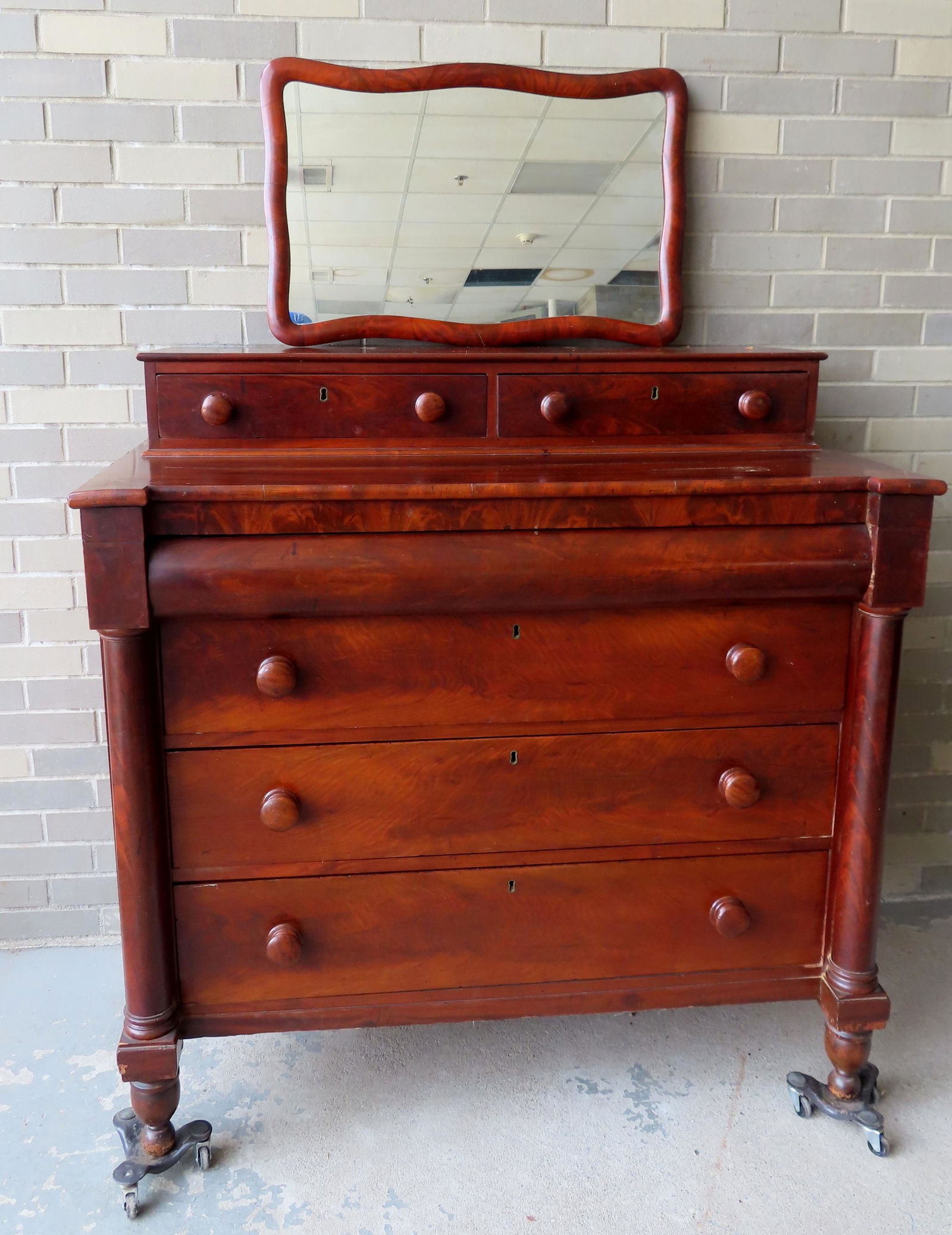 An Empire mahogany chest of drawers having 2 top drawers over 1/2 round long drawer over 3 graduated (1 of 12)