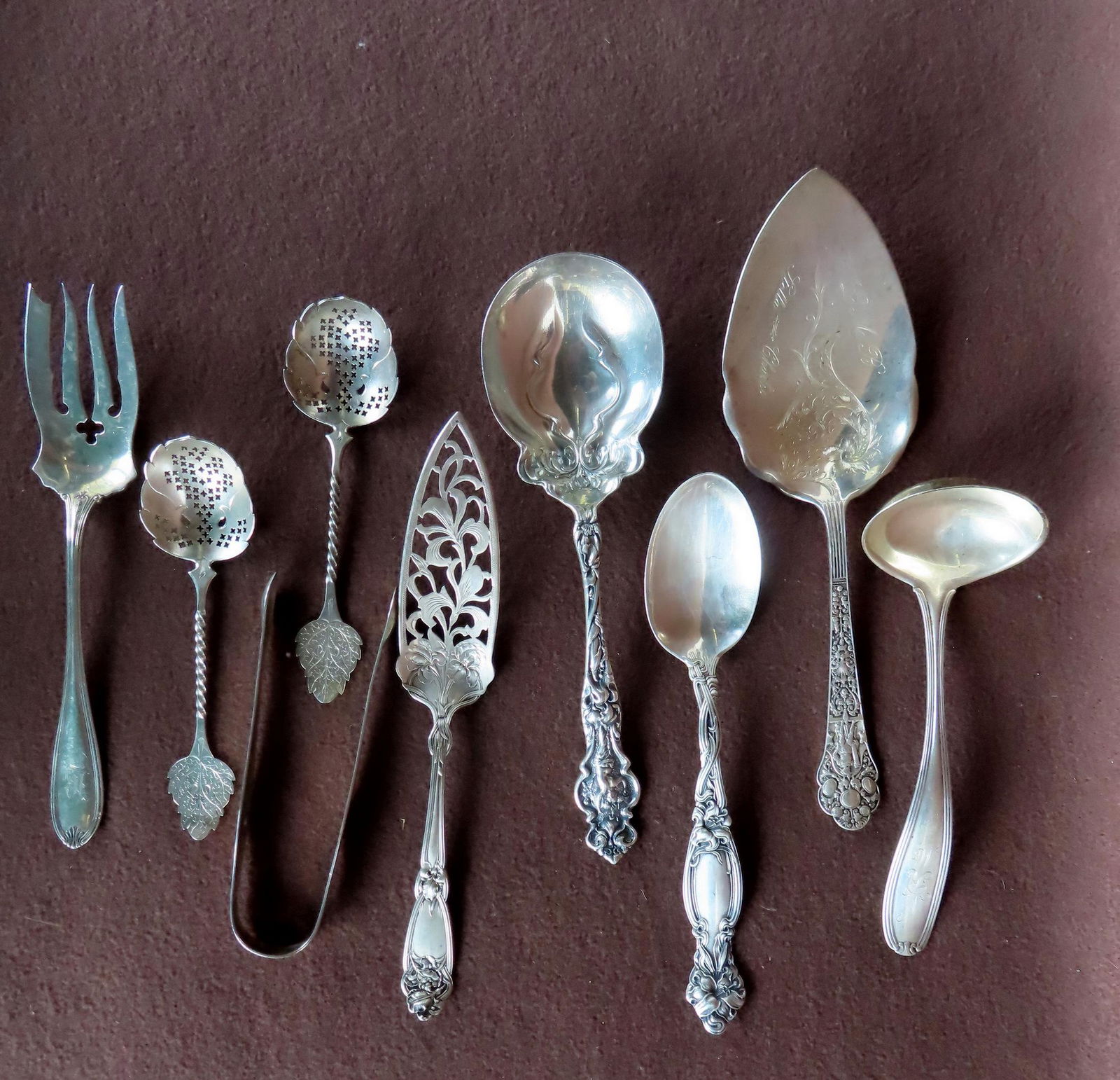 Grouping of sterling serving pieces including sugar tongs, ladle decorated with an embossed knight (1 of 6)