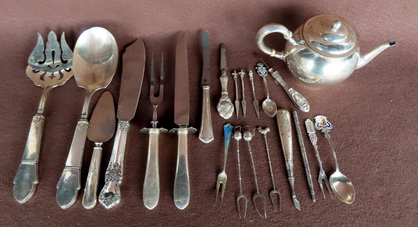 Grouping of 19 pieces of silver, most with sterling handles. Includes a pickle fork marked .800, 3 (1 of 7)