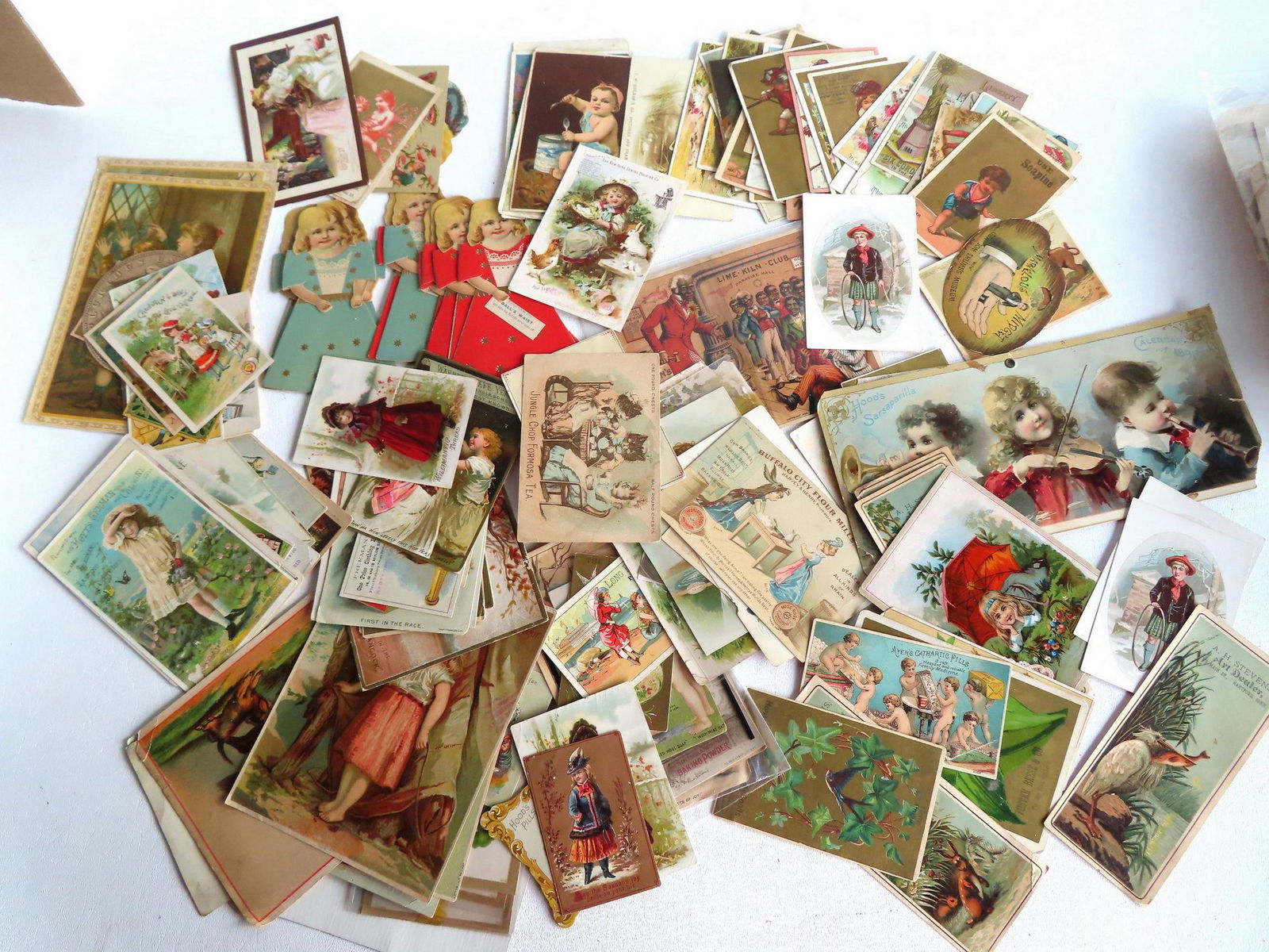 A grouping of 145 trade cards including 9 mechanical cards depicting a young lady wearing colorful (1 of 13)