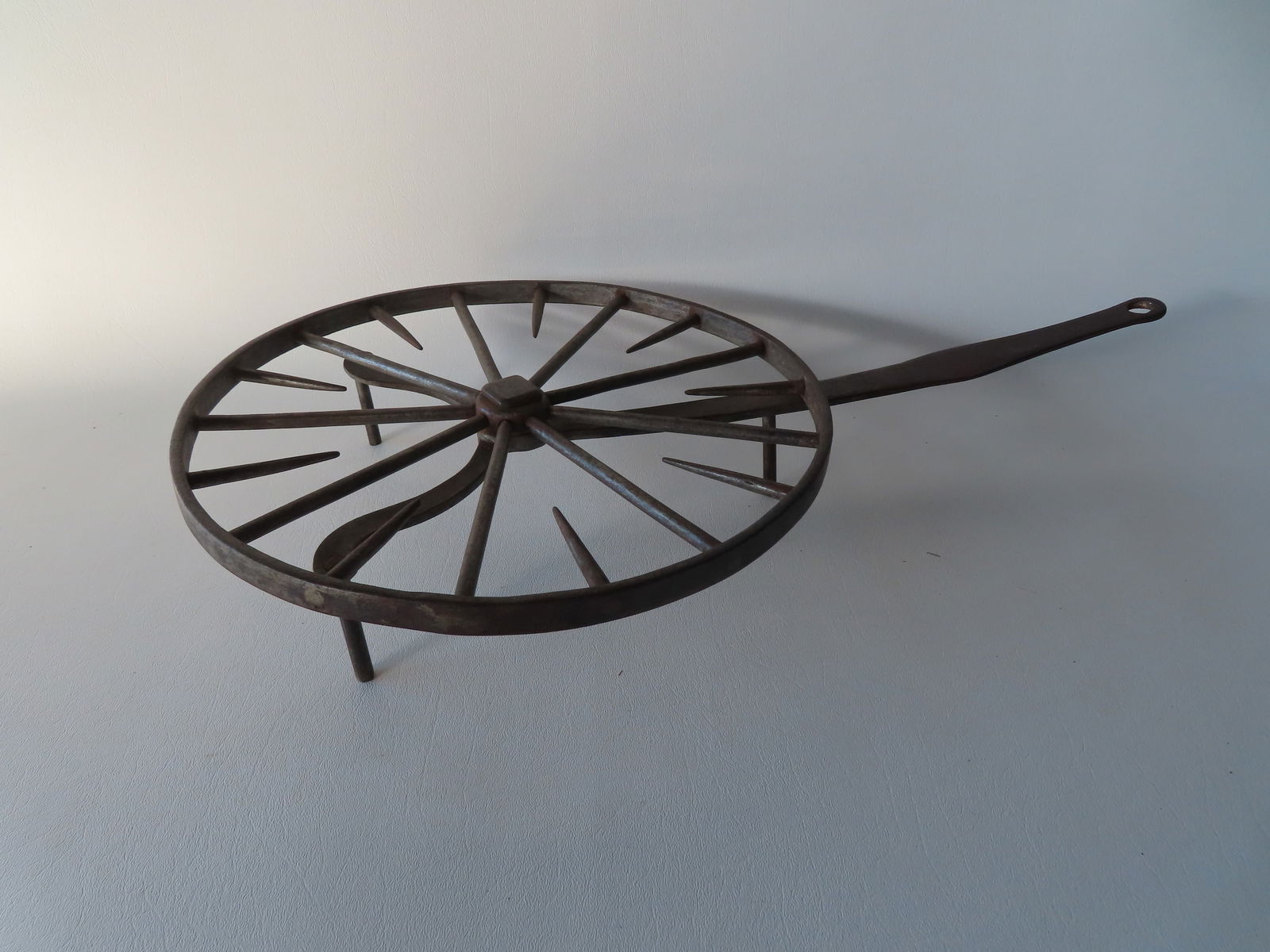 A wheel shaped hand forged iron revolving trivet, mounted on tri-feet,  late 18th to early 19th (1 of 6)