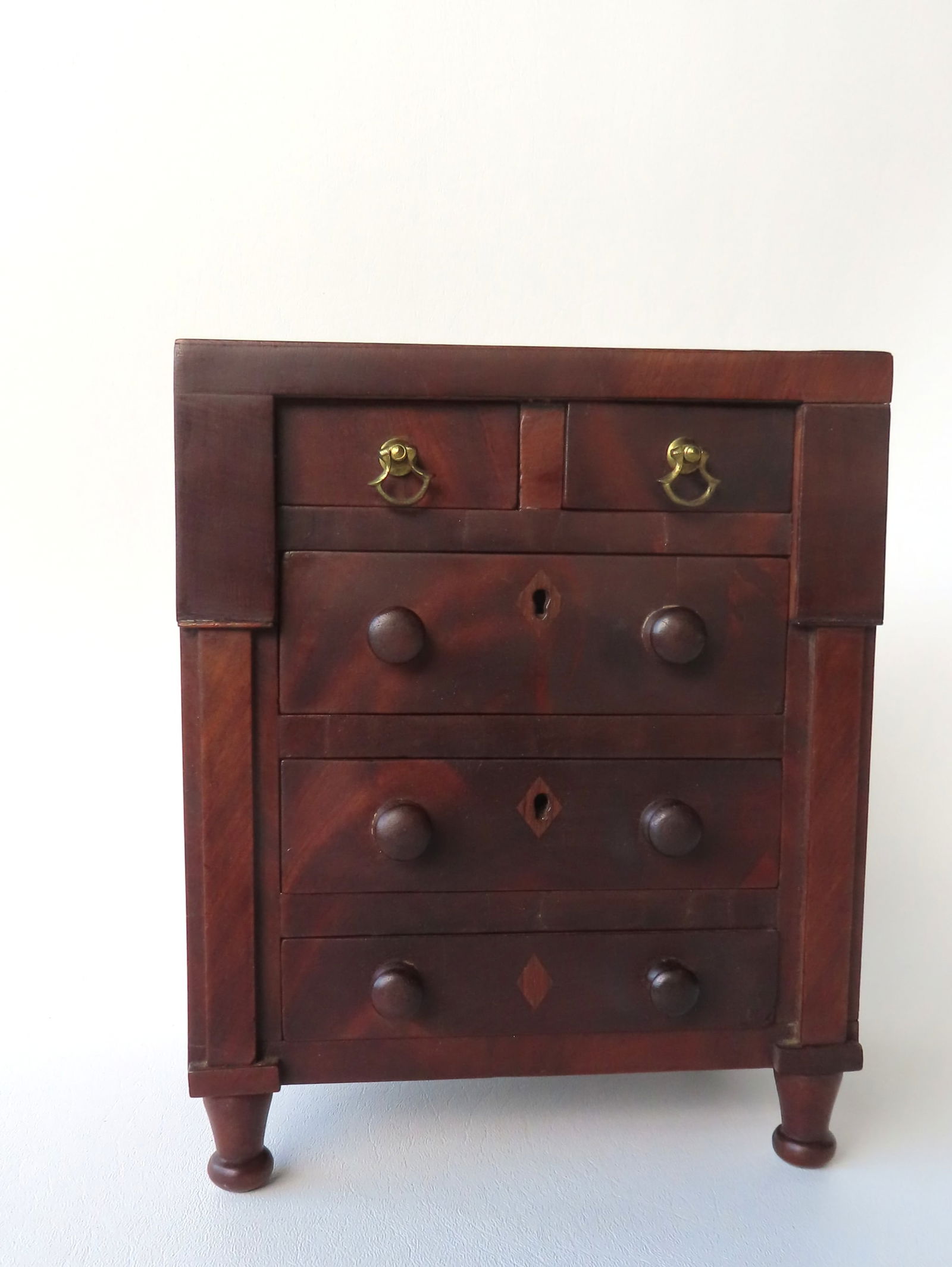A miniature mahogany  Empire 5 drawer chest having 2 short drawers over 3 long drawers flanked by (1 of 9)