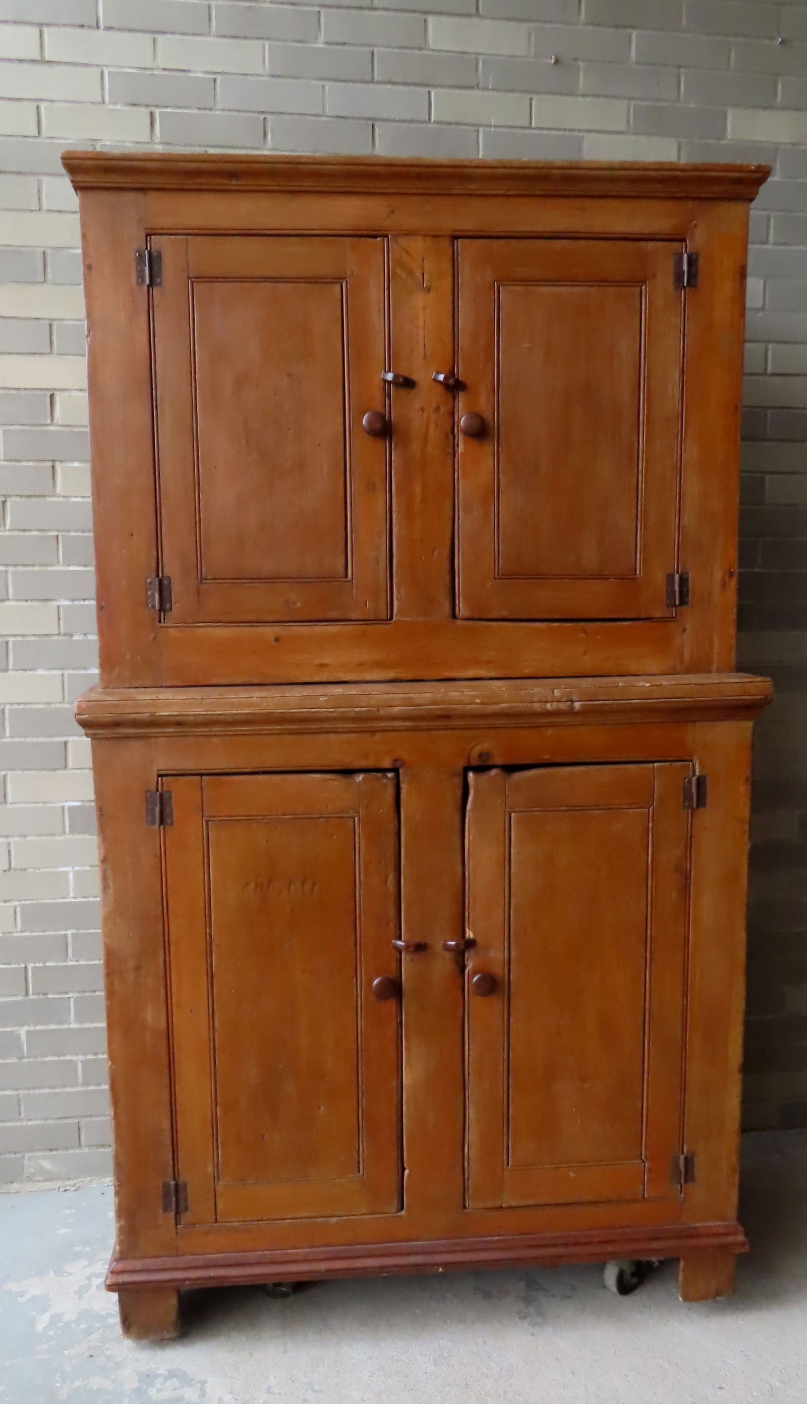 A primitive New England stepback cupboard having 2 doors over 2 doors on cutout  base, rosehead nail (1 of 16)