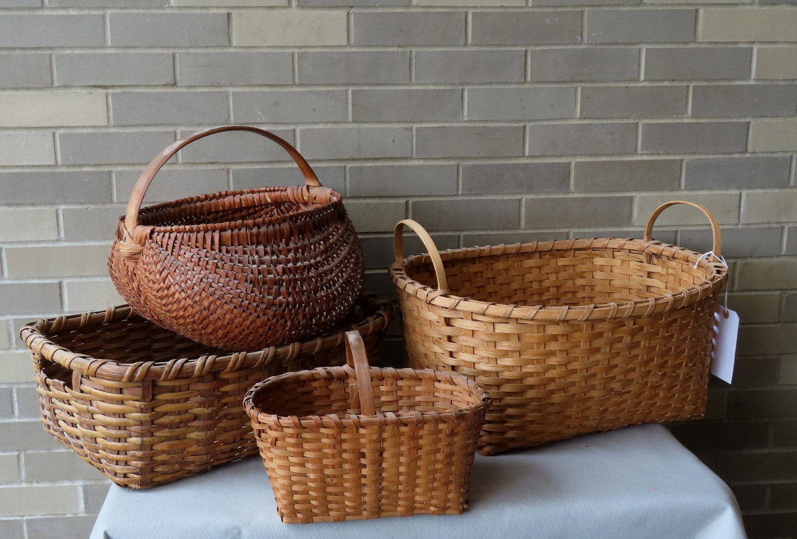 Grouping of 4 splint basket, most in very good condition. The largest measures 21 1/4"L x 18"D x 13: Grouping of 4 splint basket, most in very good condition. The largest measures 21 1/4"L x 18"D x 13 1/2"H to top of handle. Late 19th to early 20th century. Provenance: From a NJ collector, downsizing