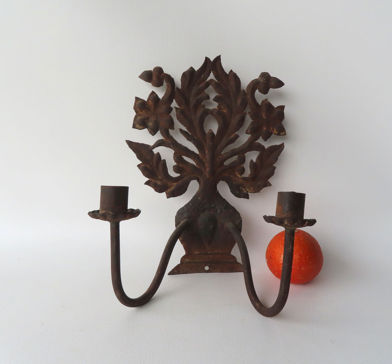 A tin candle wall sconce with 2 fonts and having a back plate in the form of an urn with flowers, (1 of 7)