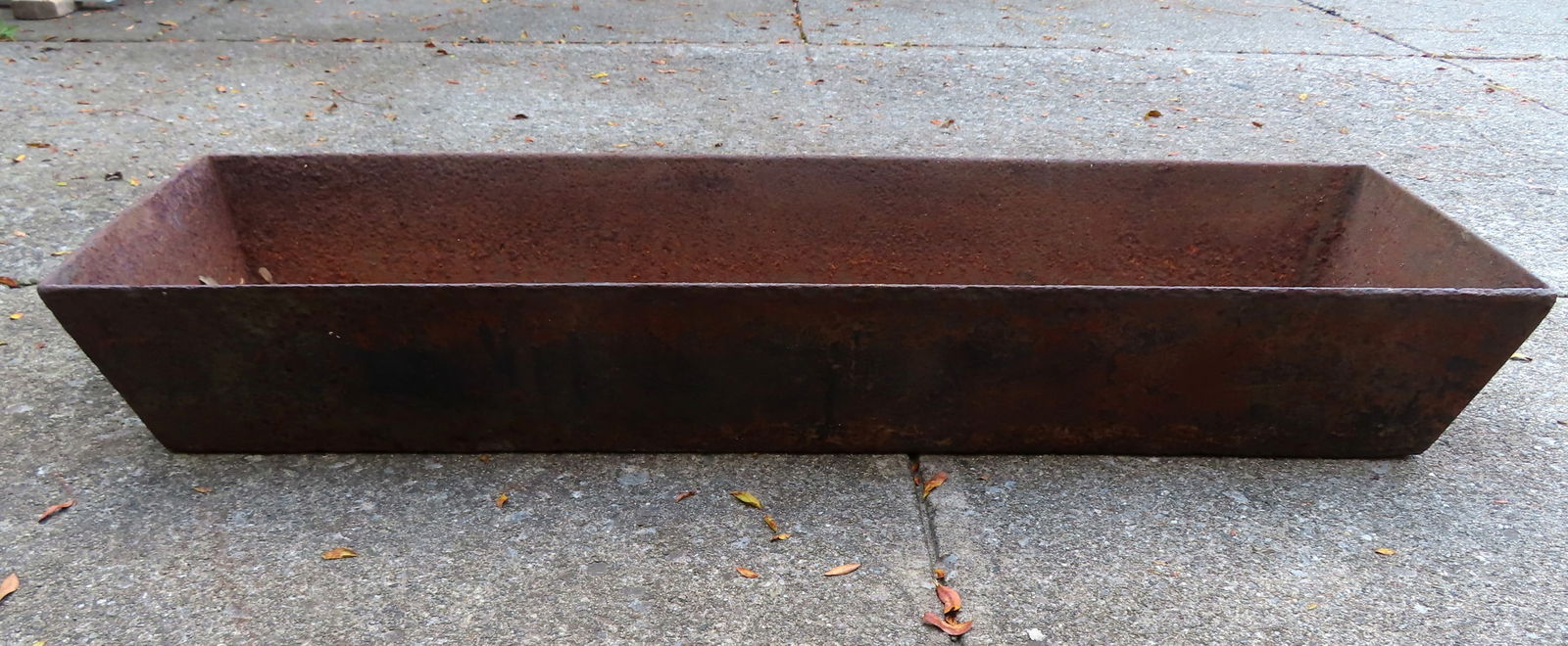 A cast iron pig's trough, late 19th to early 20th century, some rusting and hairline on one end, (1 of 4)