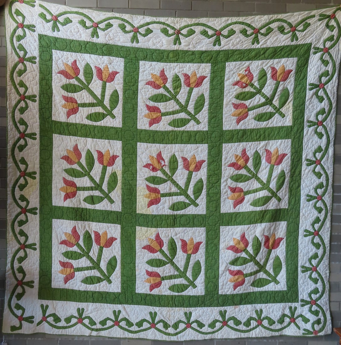 A floral applique quilt decorated with tulips and having a  leaf and vine border, all hand sewn, (1 of 8)