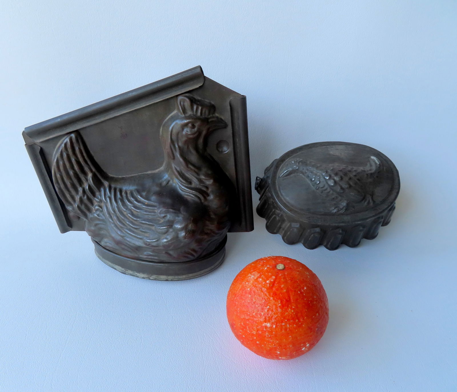 Two early tin chocolate and pudding molds including: A 2 part hen on nest measuring 8"W x 7 1/2"H; (1 of 6)