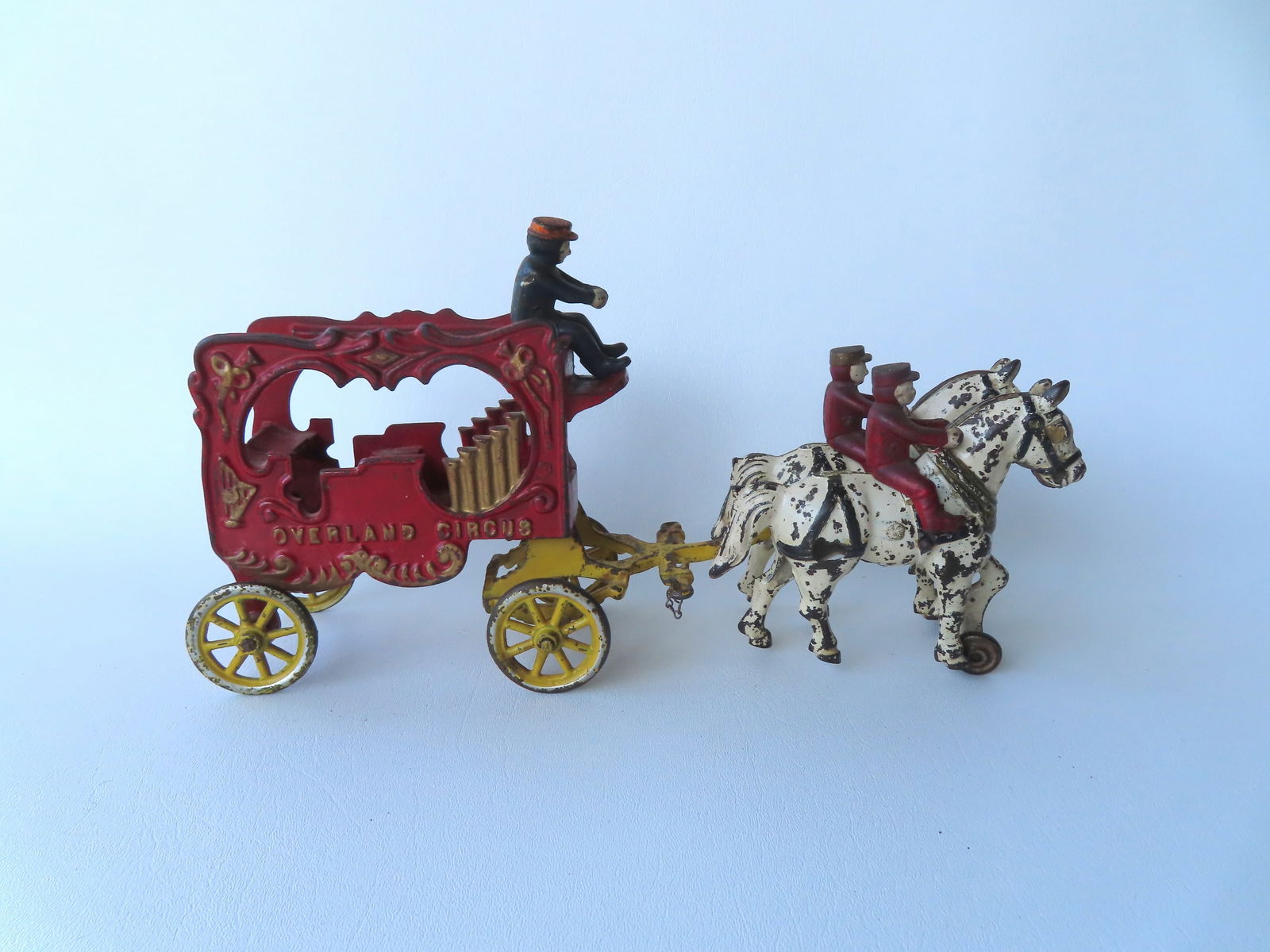 A cast iron horse drawn circus wagon pulled by 2 horses marked "OVERLAND CIRCUS" in original paint, (1 of 11)